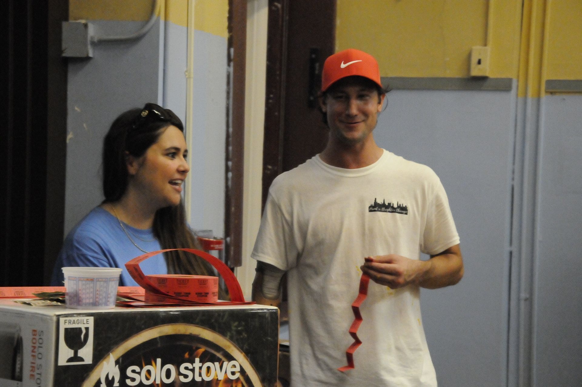 A man and a woman are standing in front of a solo stove