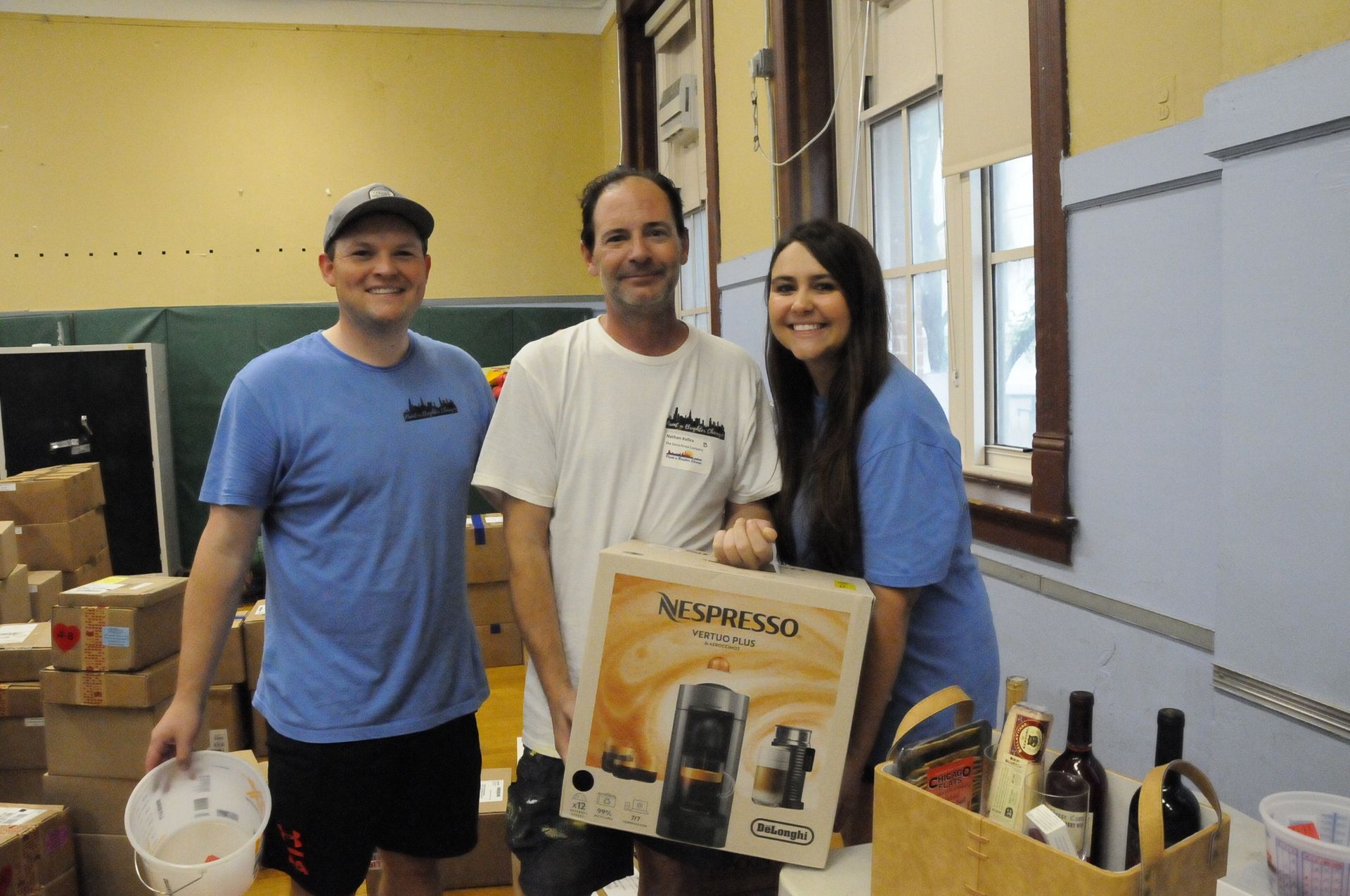 Three people standing next to a box that says nespresso