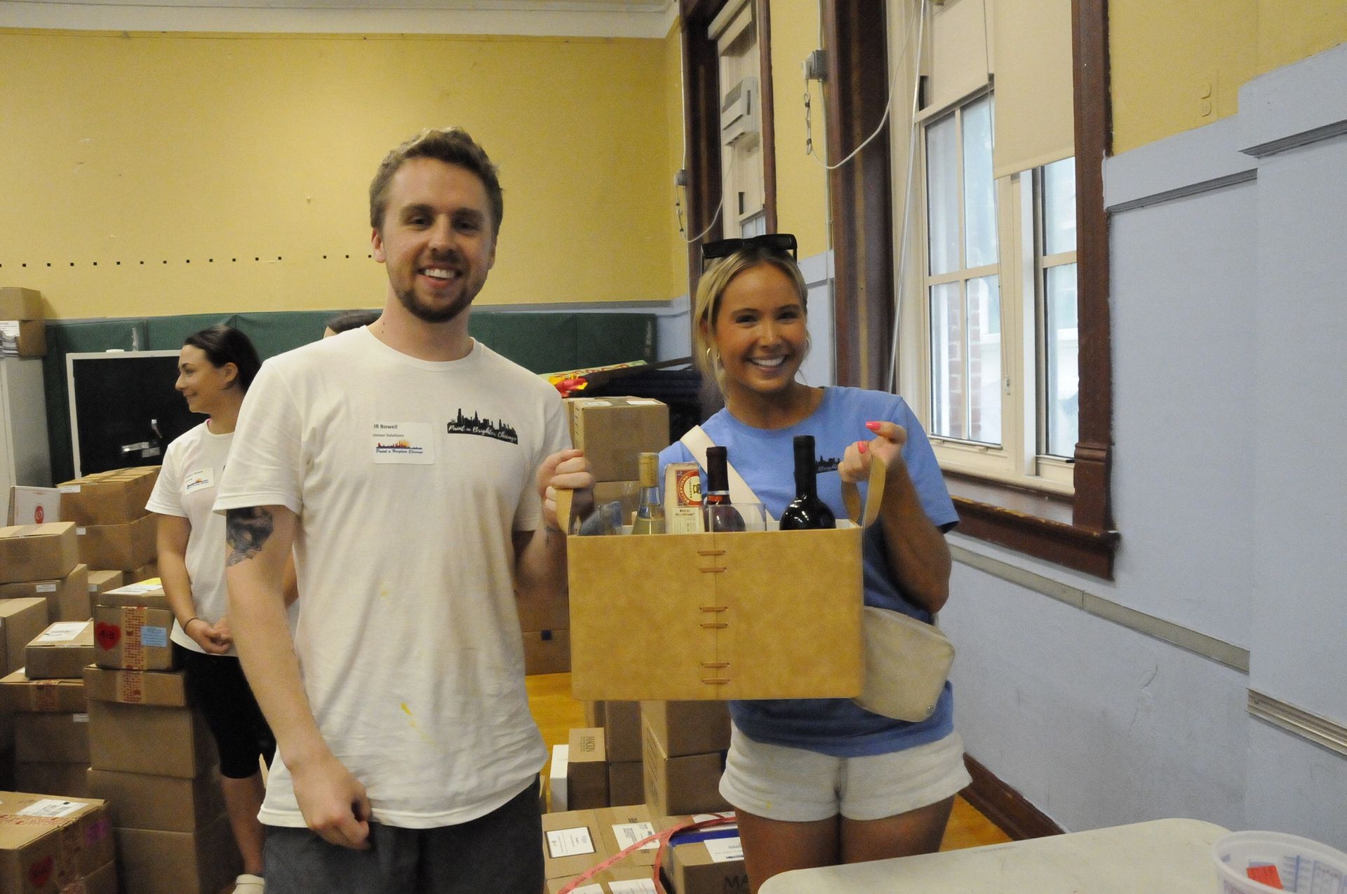 A man and a woman standing next to each other holding a wooden box