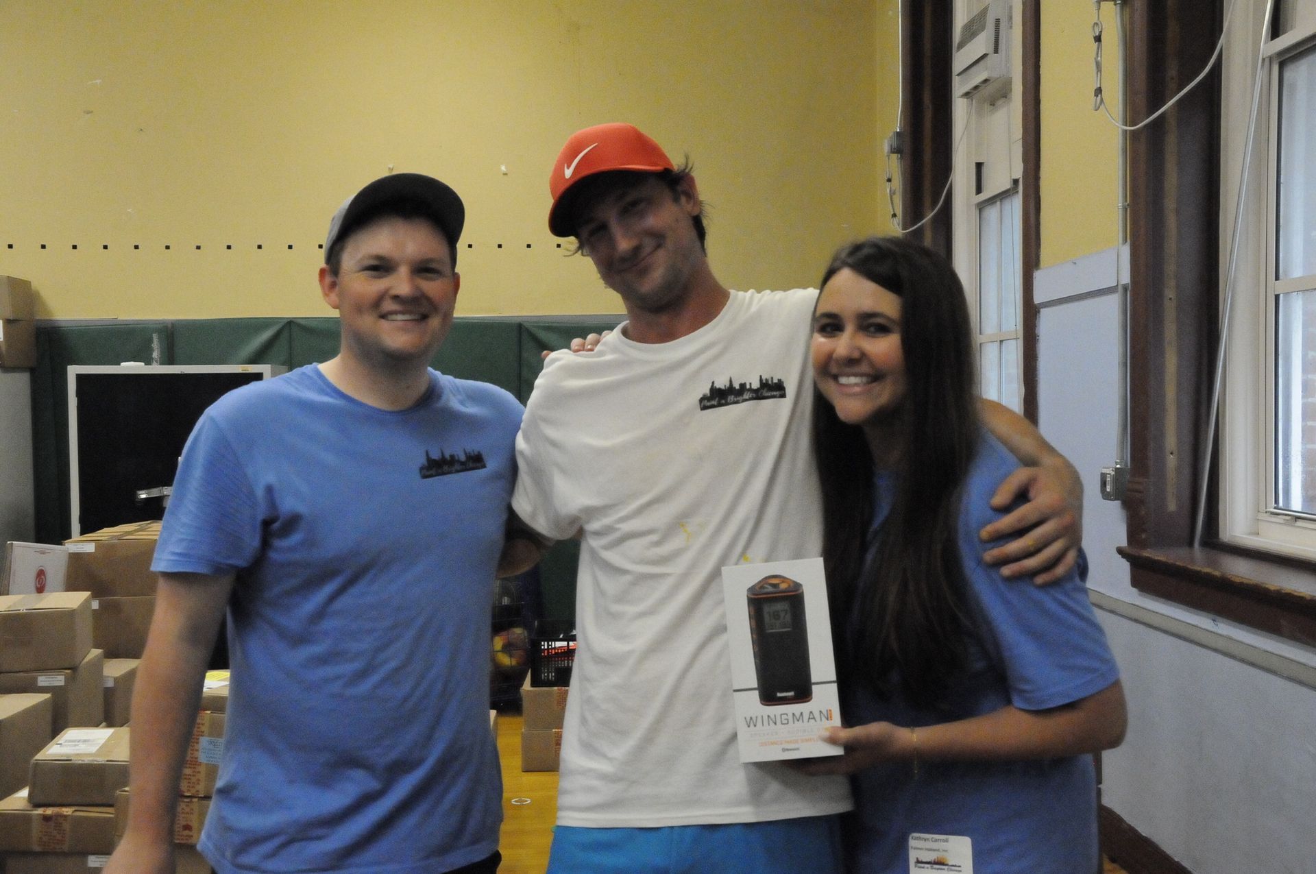 Three people posing for a picture with one holding a cell phone