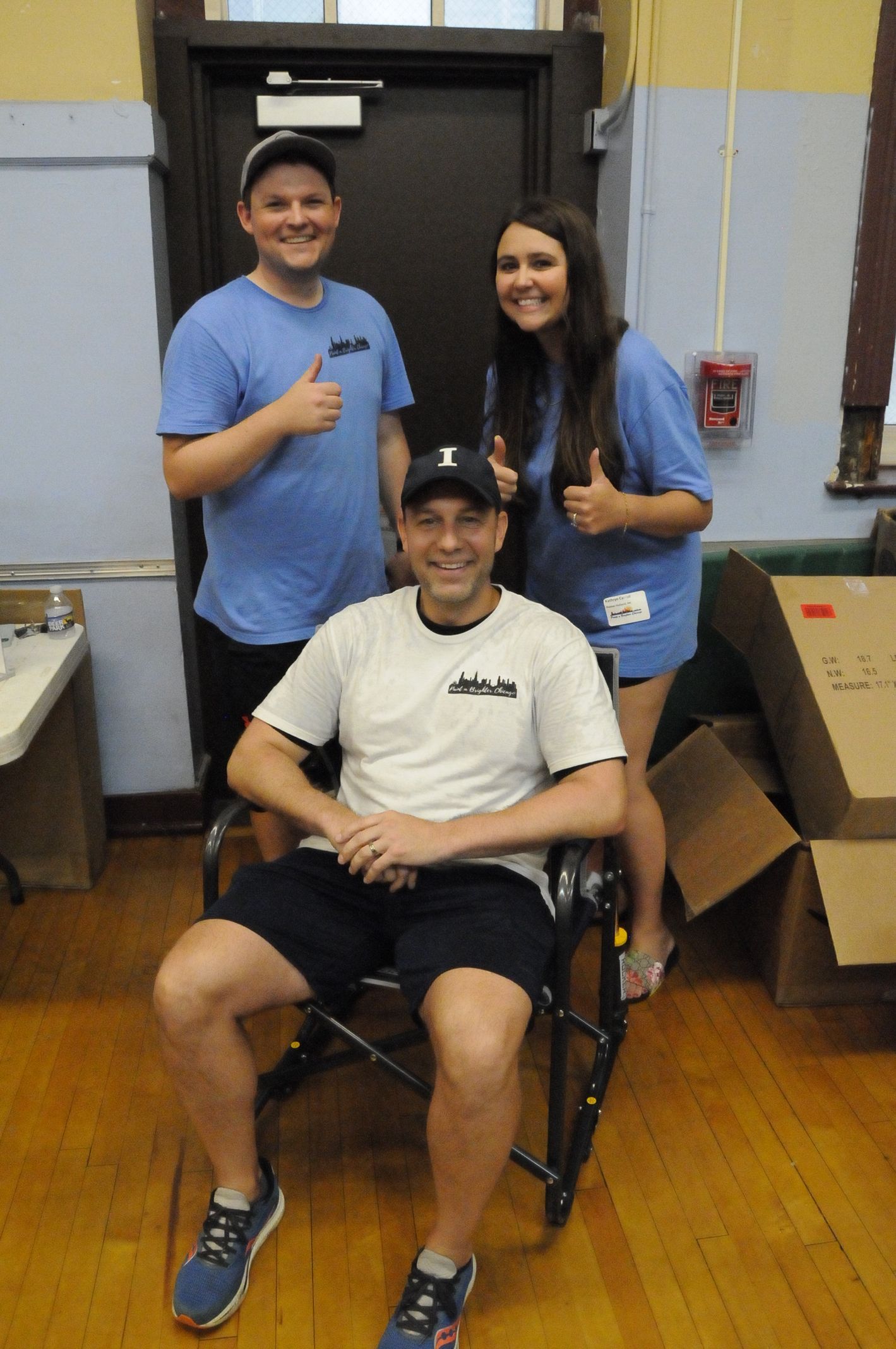 A man in a wheelchair is posing for a picture with two other people