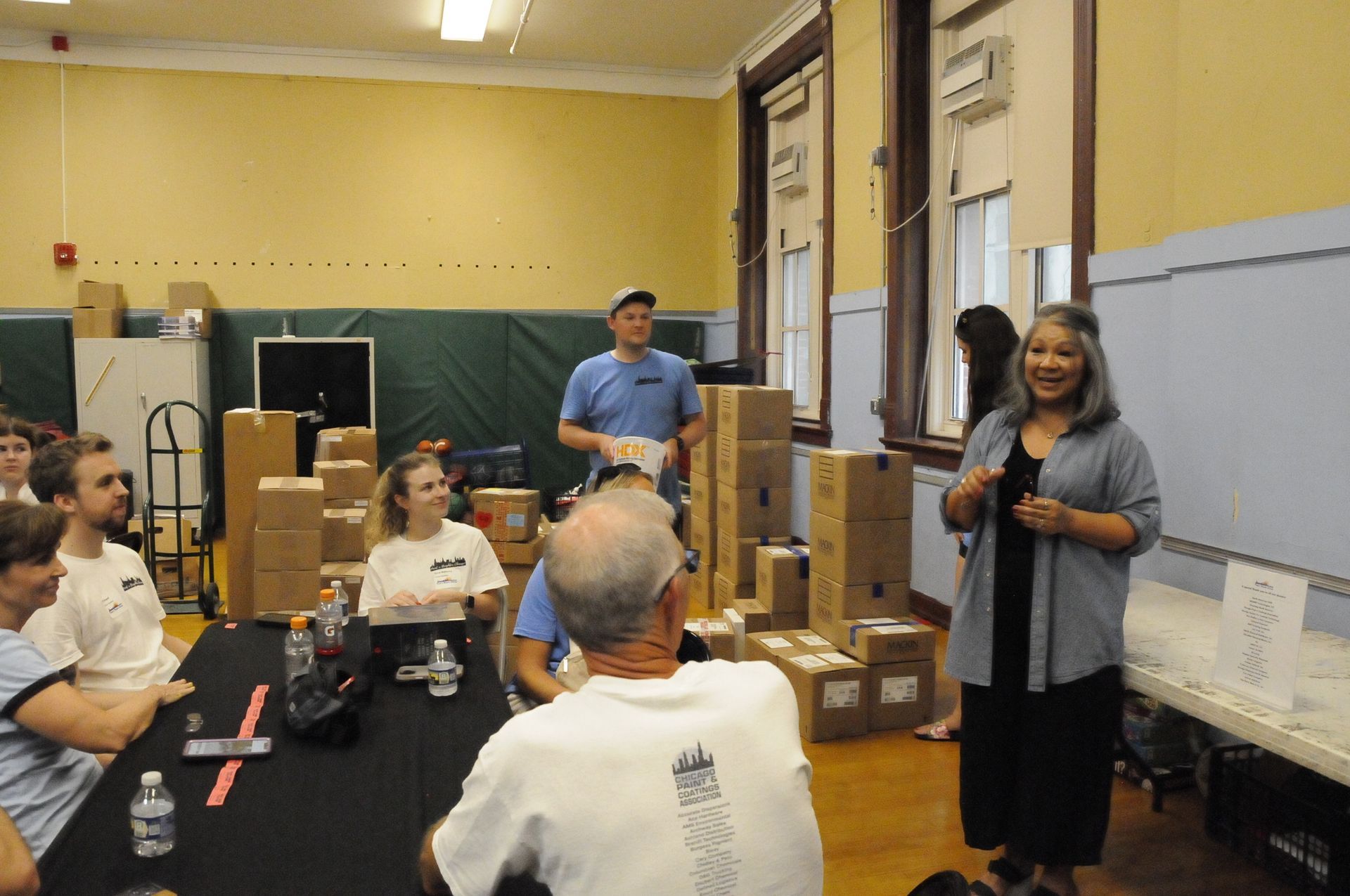 A group of people sitting around a table with boxes on the floor