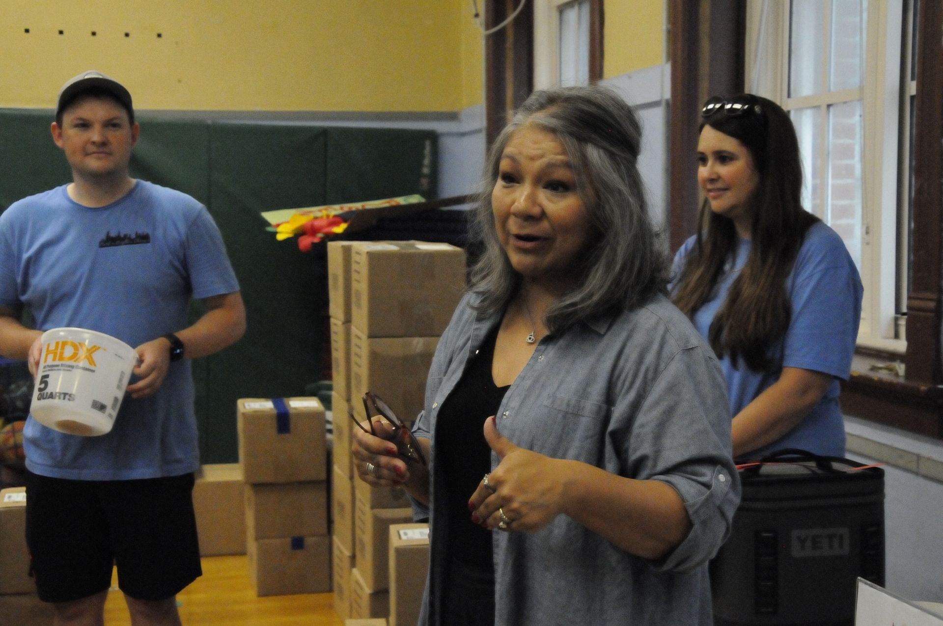 A woman giving a thumbs up in a room with boxes