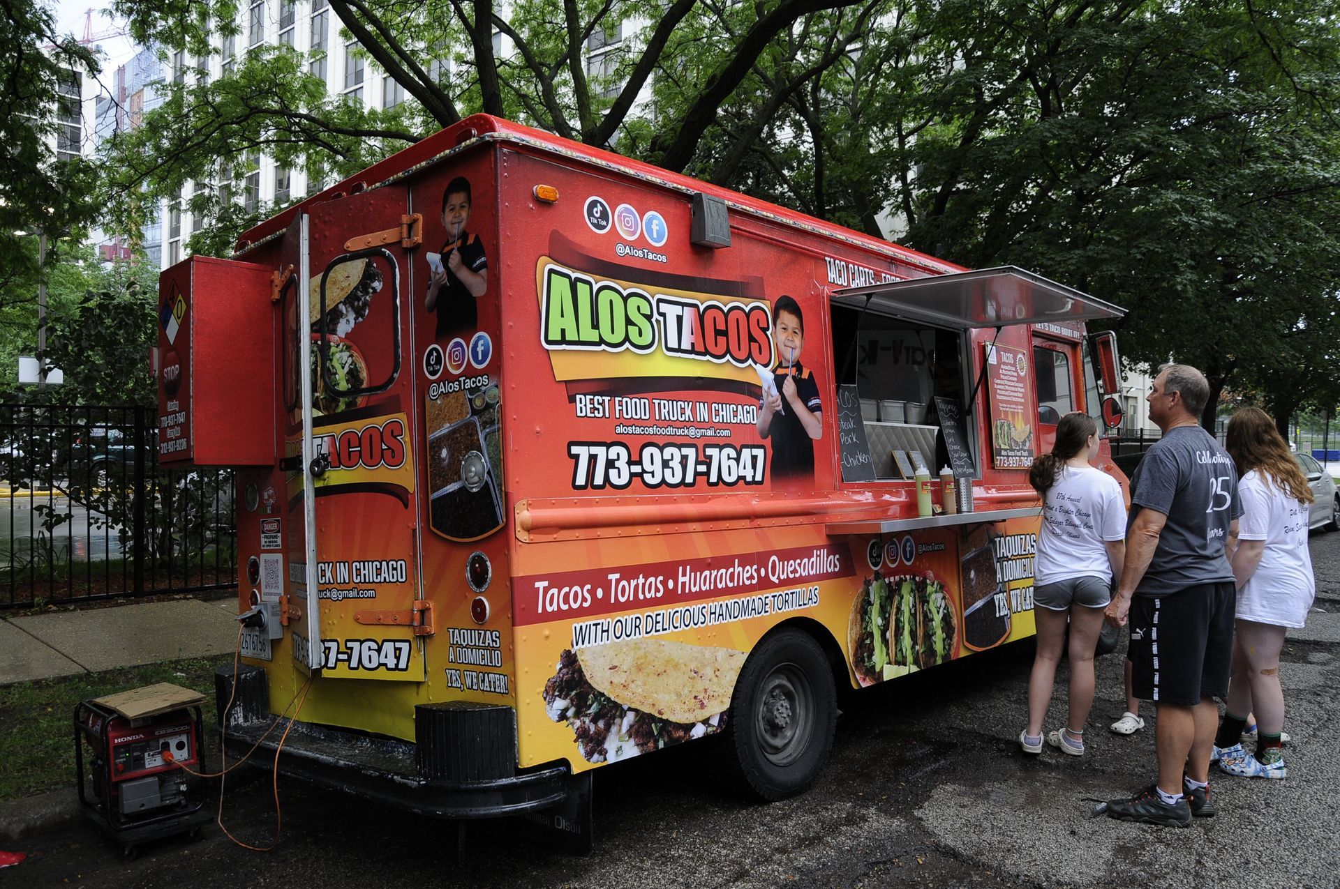 A group of people are standing in front of a food truck.