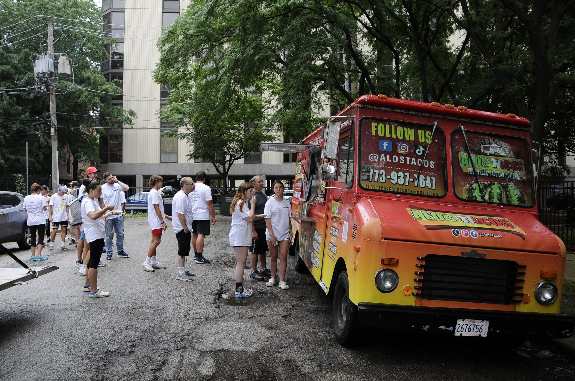 A group of people are standing in front of a food truck.