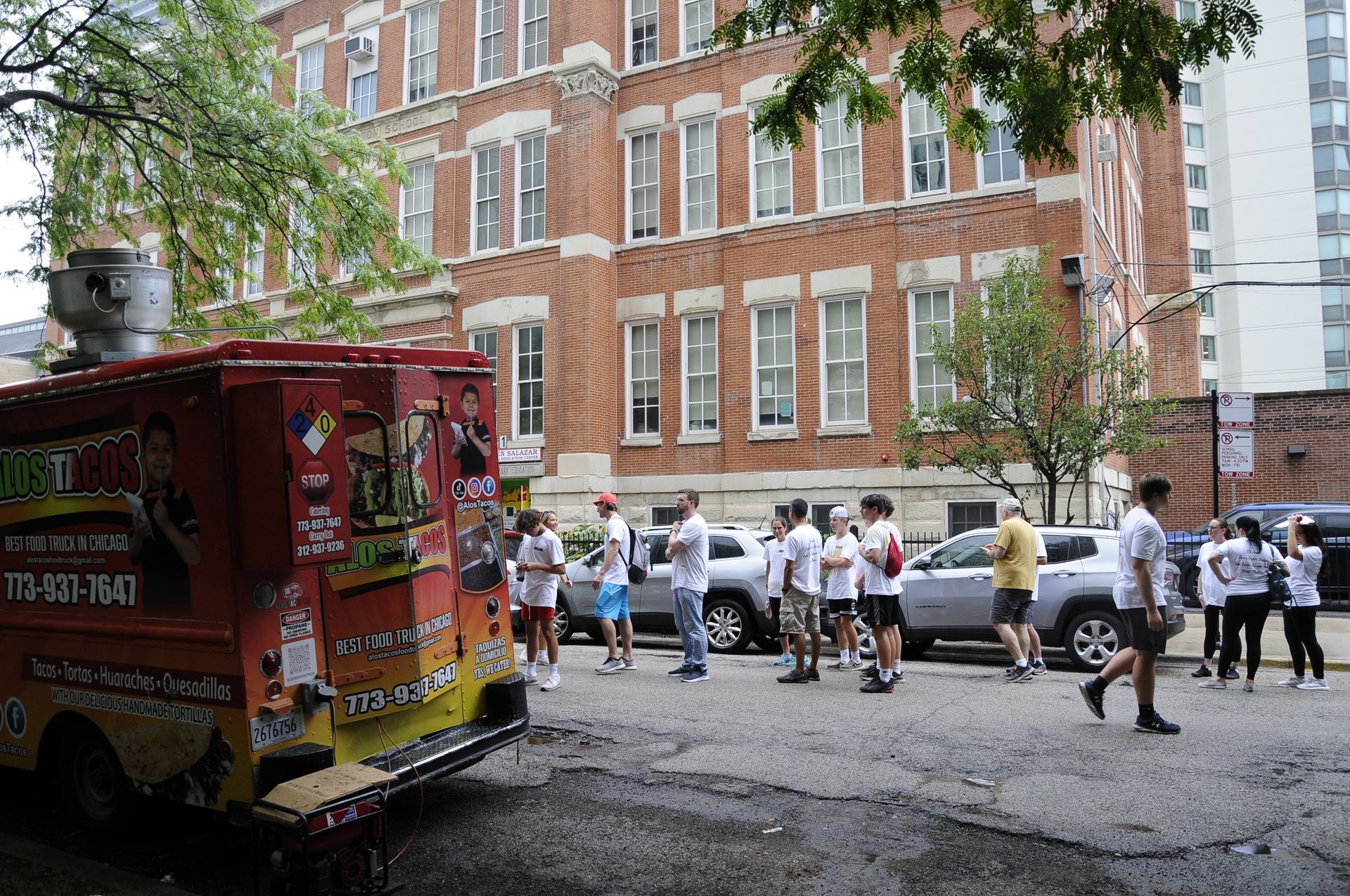 A group of people are standing in front of a food truck