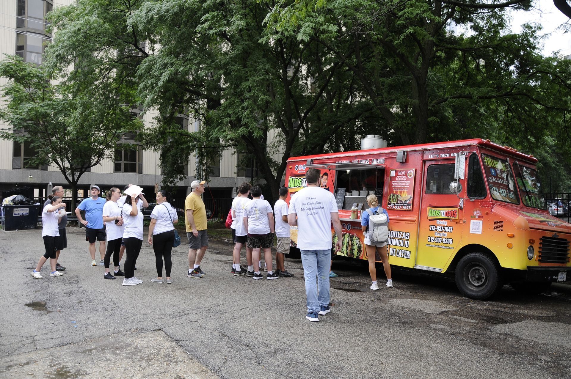 A group of people standing in front of a food truck