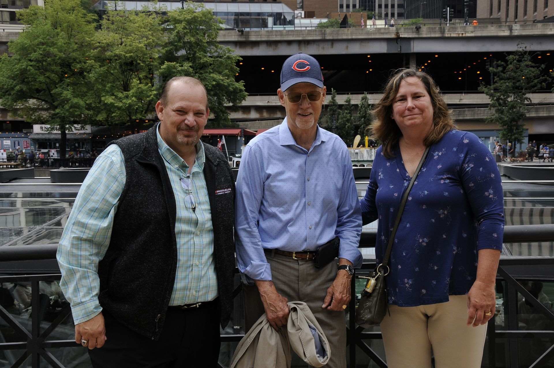 Three people are posing for a picture in front of a building