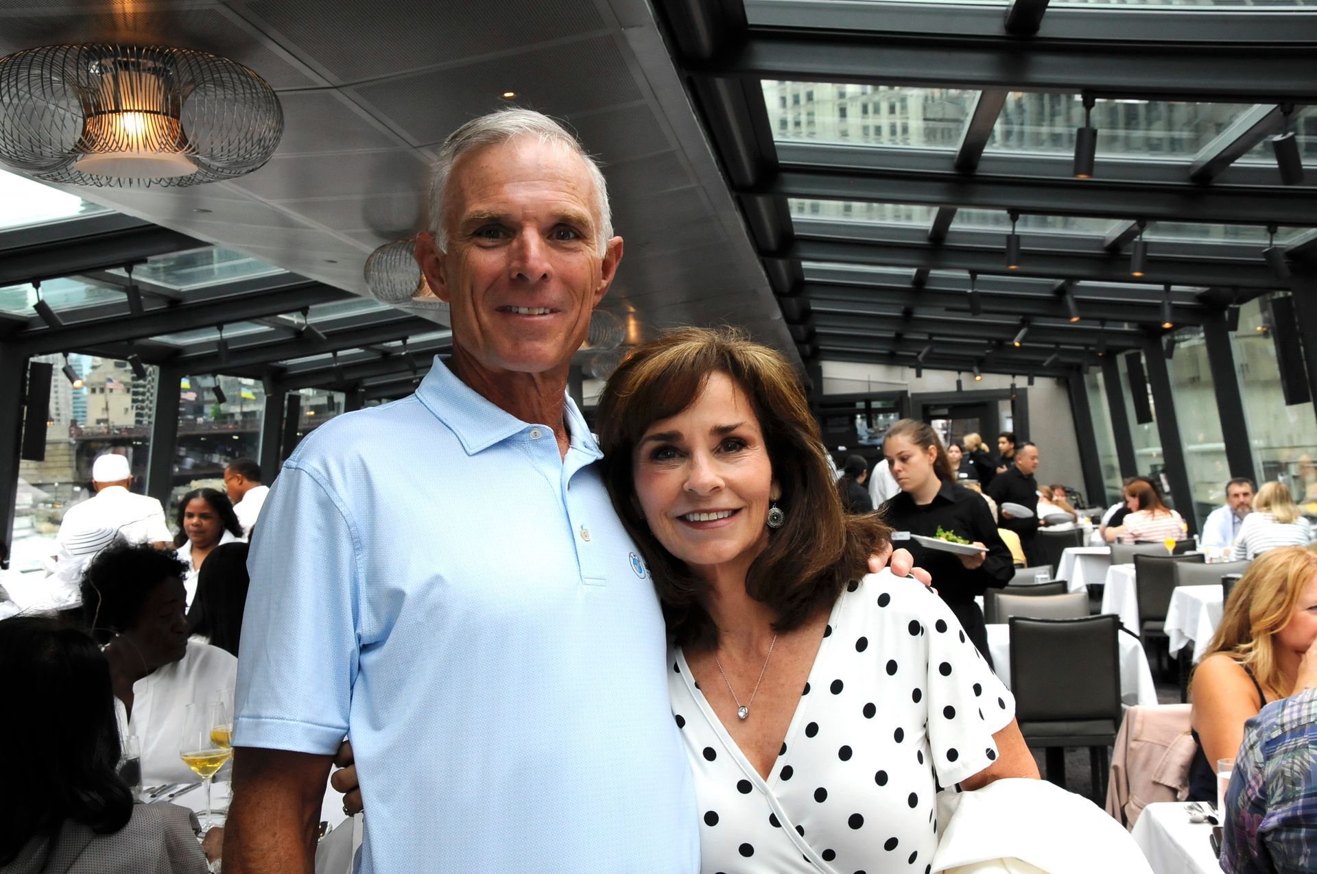 A man and a woman are posing for a picture in a restaurant.