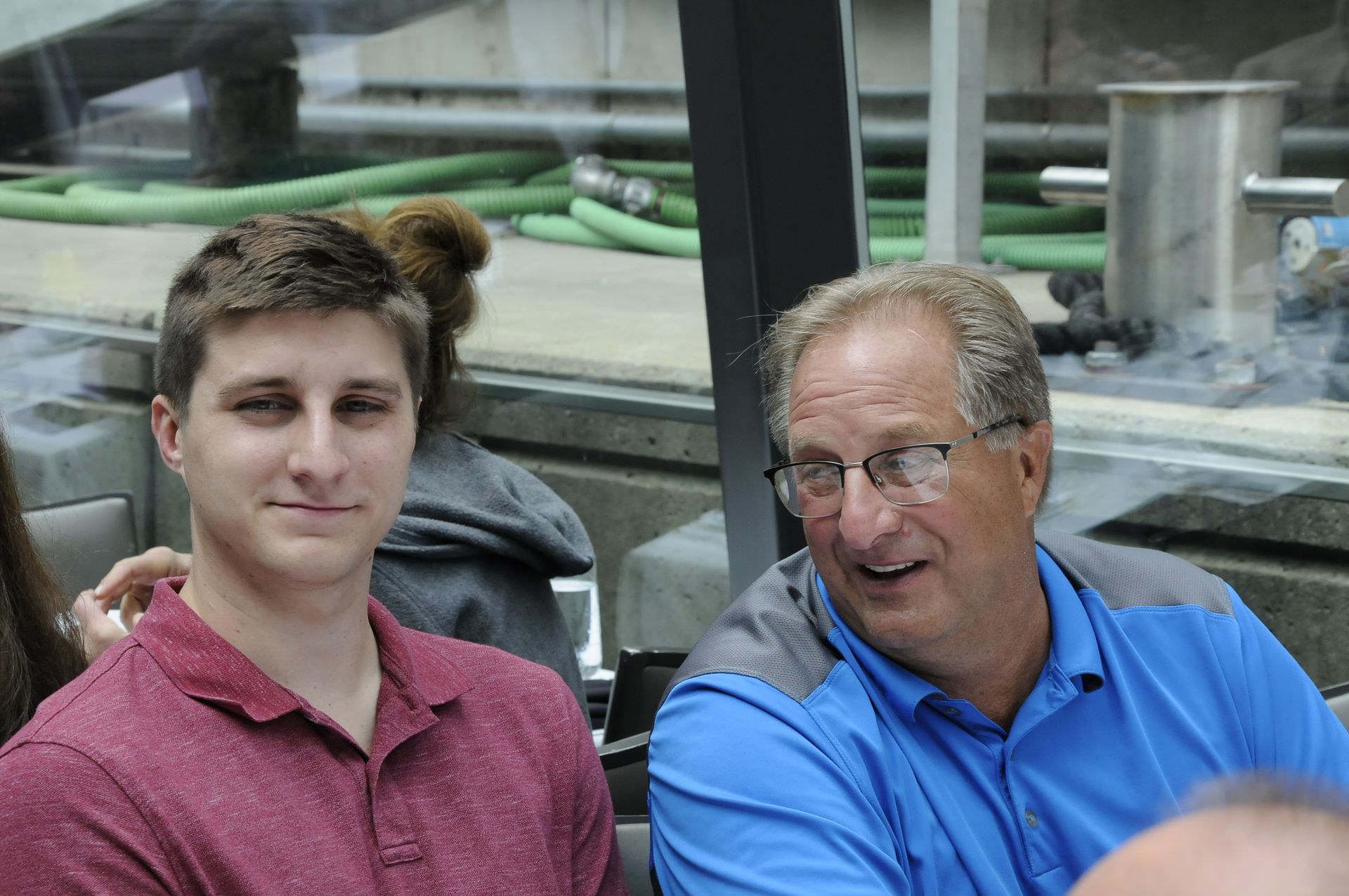 A man and a boy are sitting next to each other and smiling.