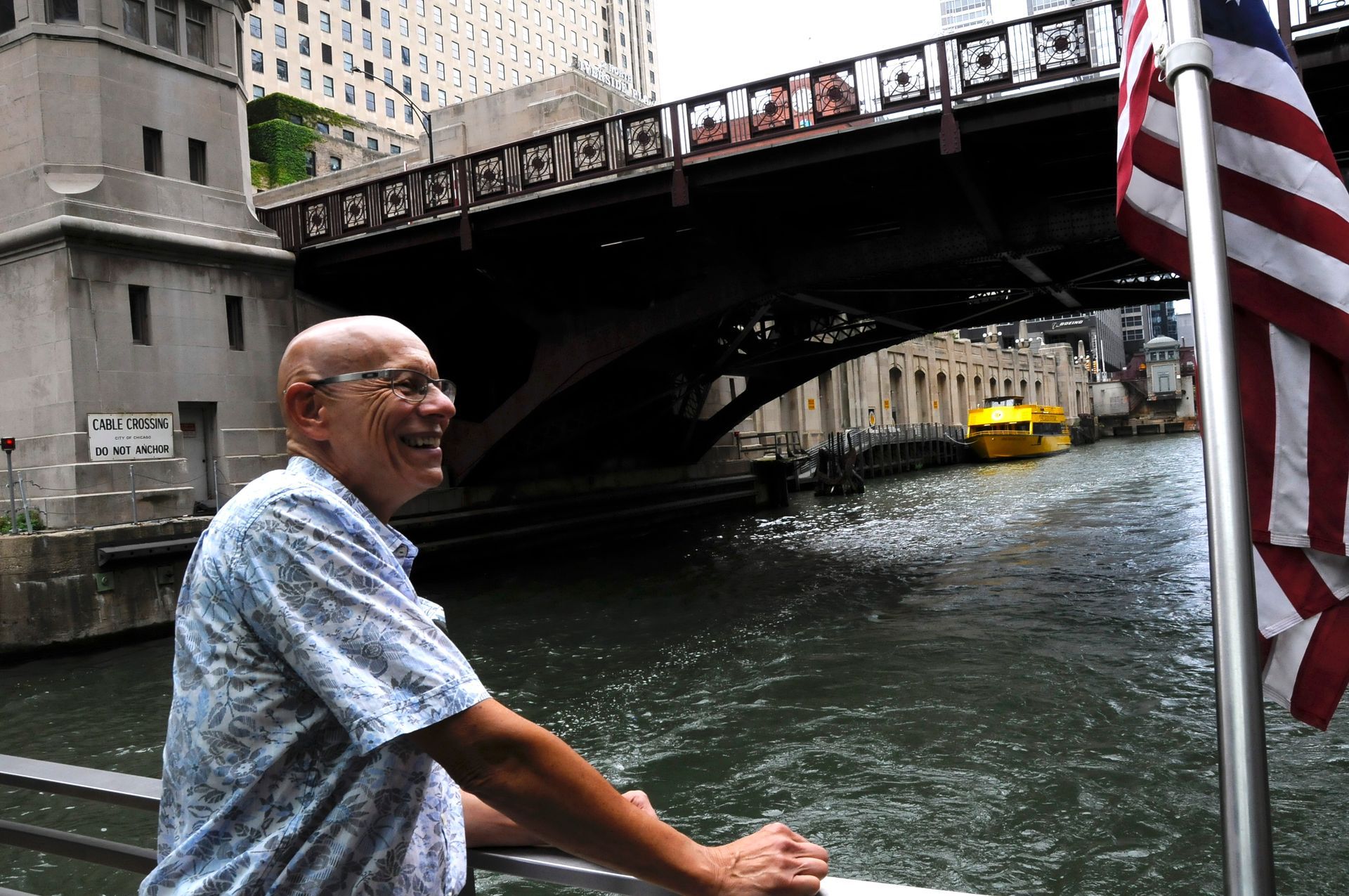 A man stands in front of a bridge over a river