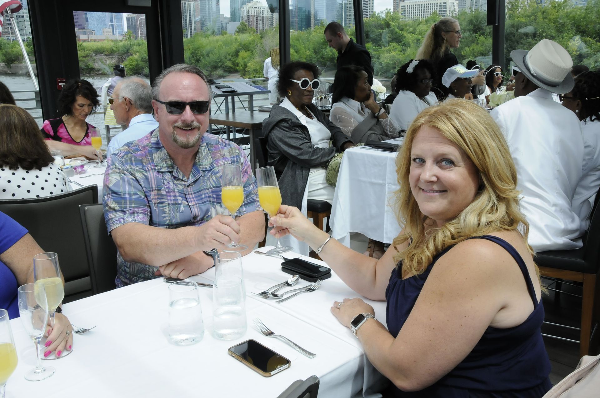 A man and a woman are sitting at a table with glasses of orange juice.