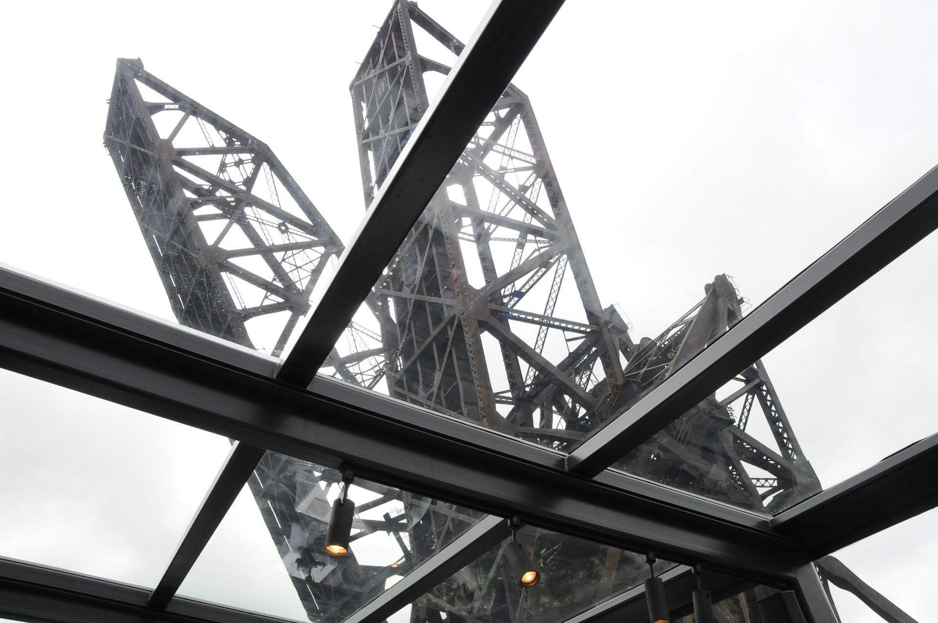 Looking up at the eiffel tower through a glass roof