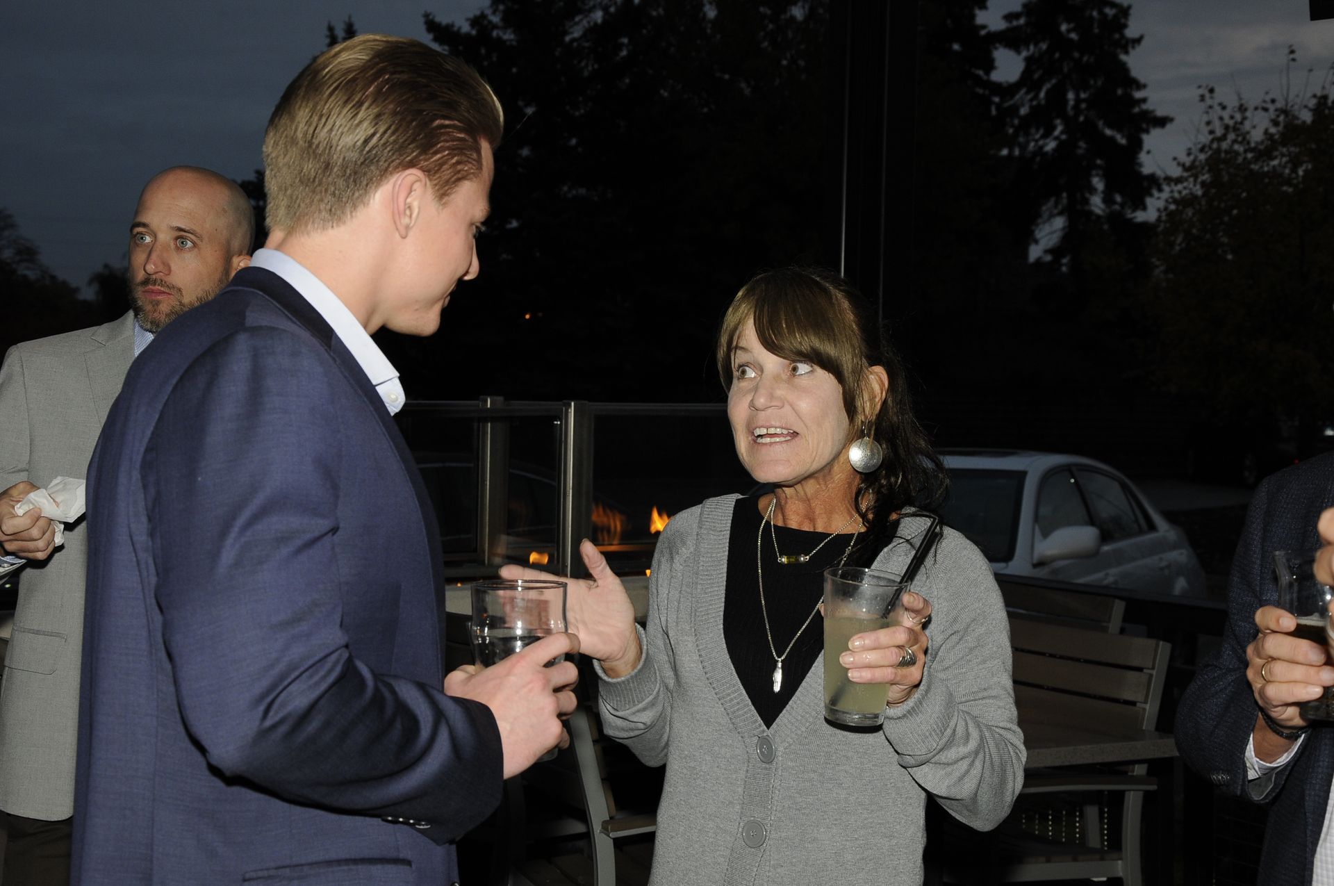 A man and a woman are talking to each other while holding drinks