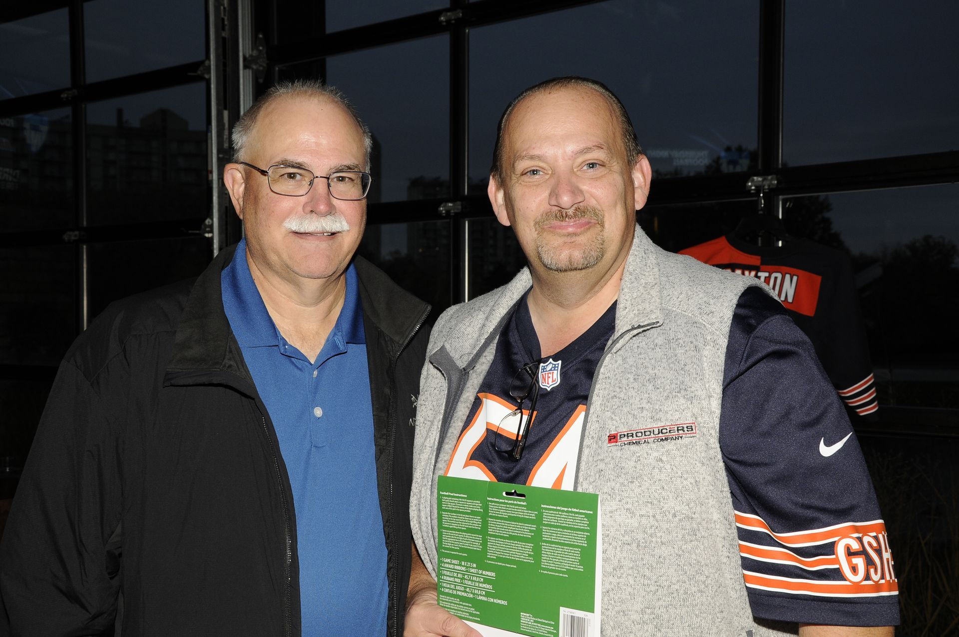 Two men standing next to each other one wearing a bears jersey