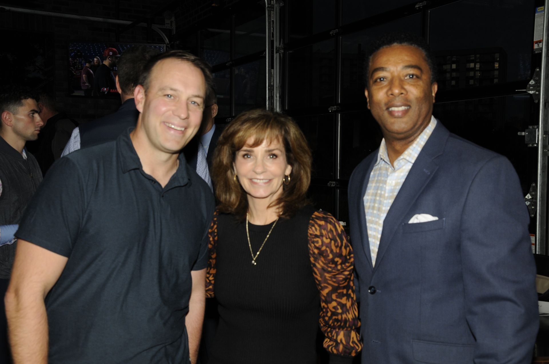 Two men and a woman are posing for a picture together