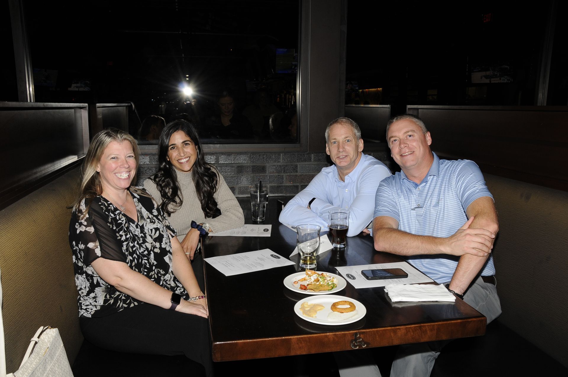 A group of people are sitting at a table in a booth.