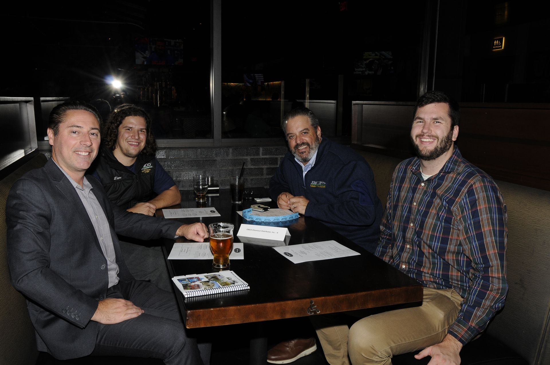 A group of men are sitting at a table in a restaurant.
