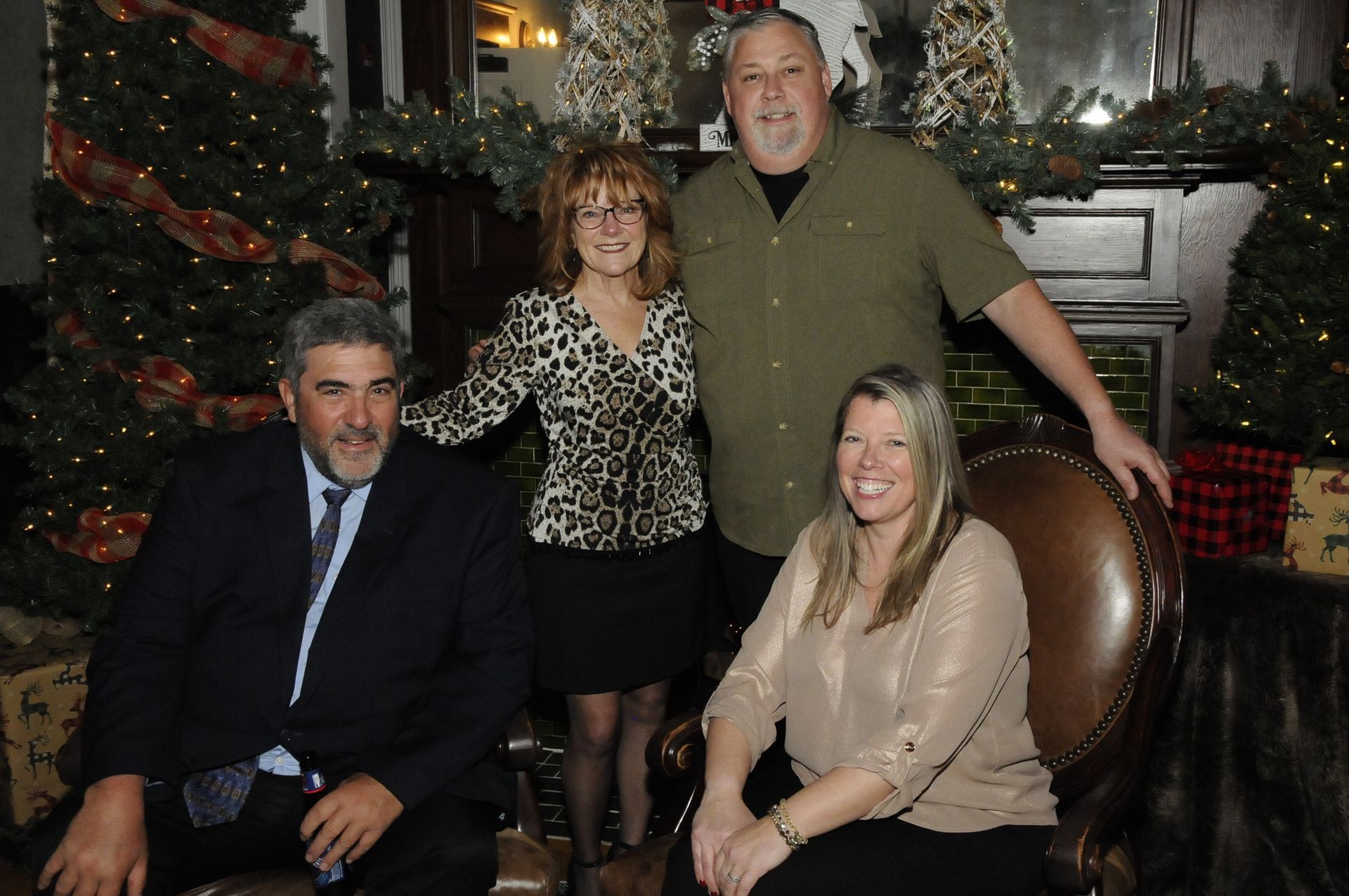 A group of people posing for a picture in front of a christmas tree