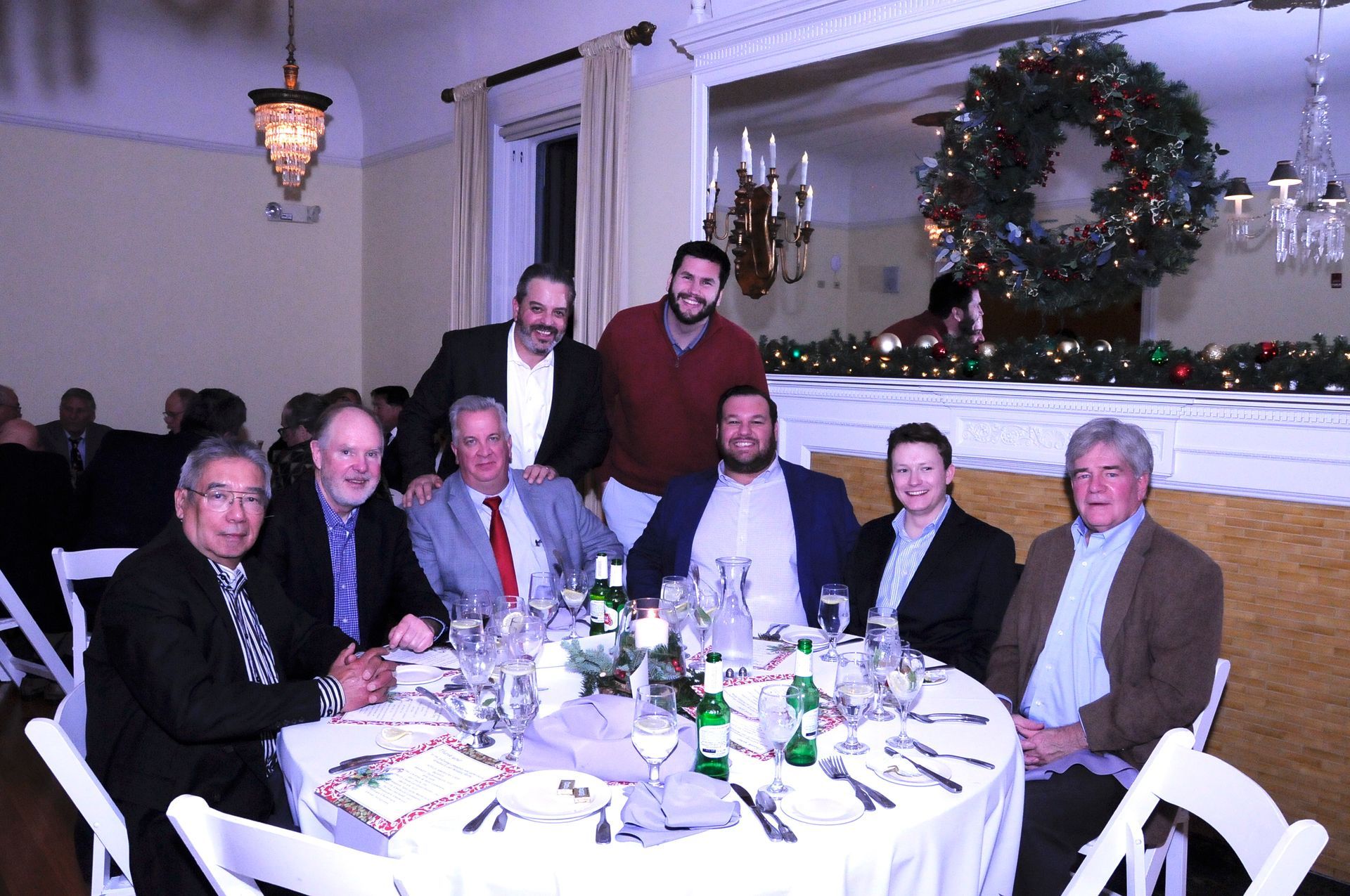 A group of men are posing for a picture at a dinner table.