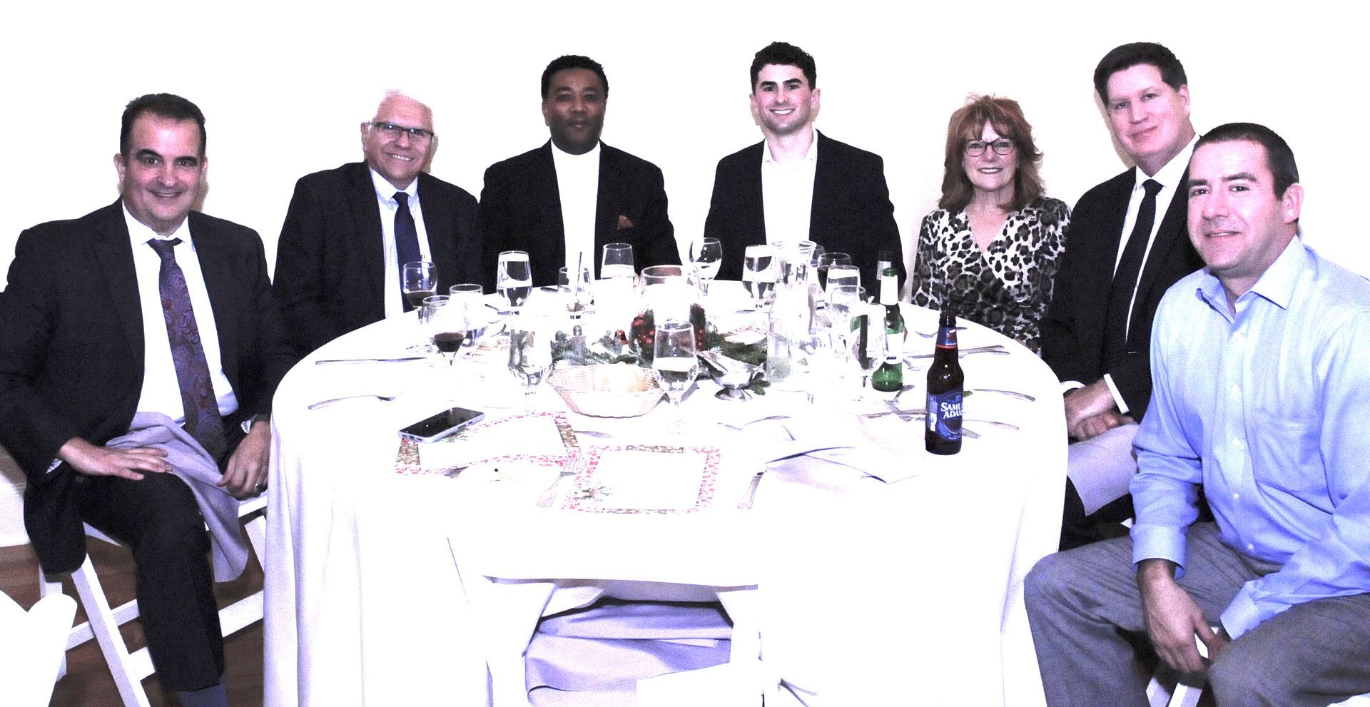 A group of people are sitting around a white table