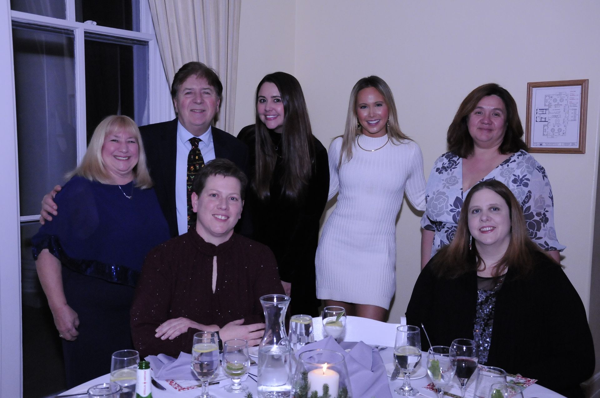 A group of people are posing for a picture at a table.