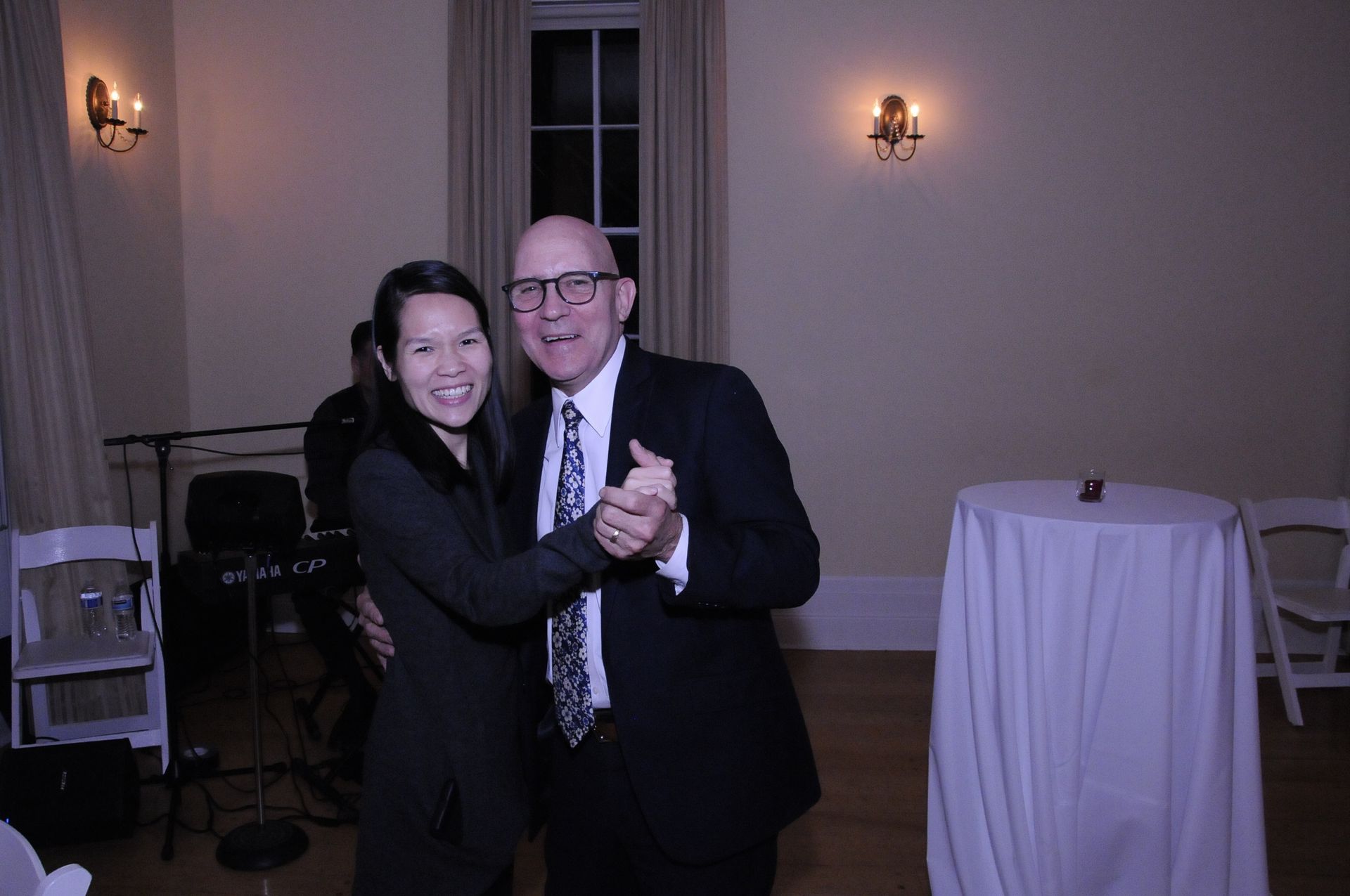 A man and a woman are dancing together in a room.
