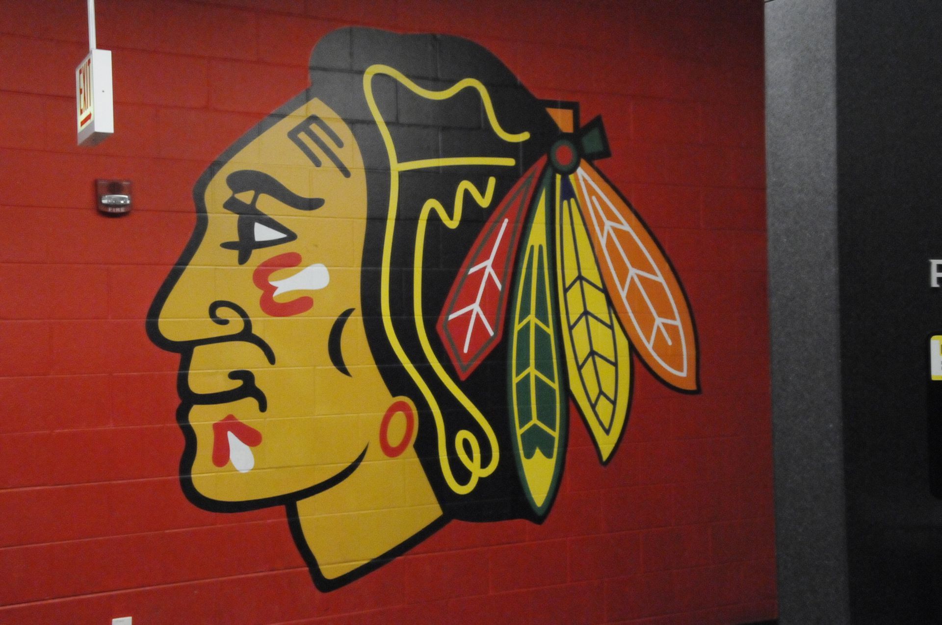 A painting of a native american on a red wall