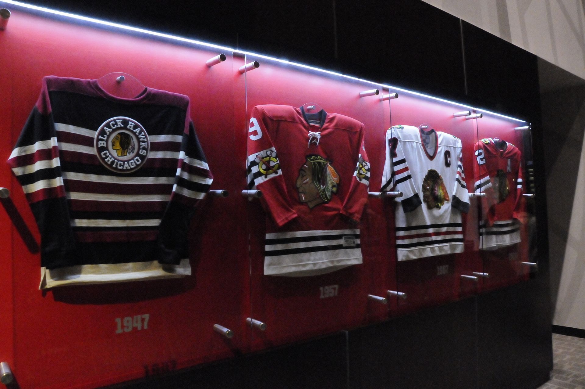 A row of hockey jerseys hanging on a wall with the year 1947