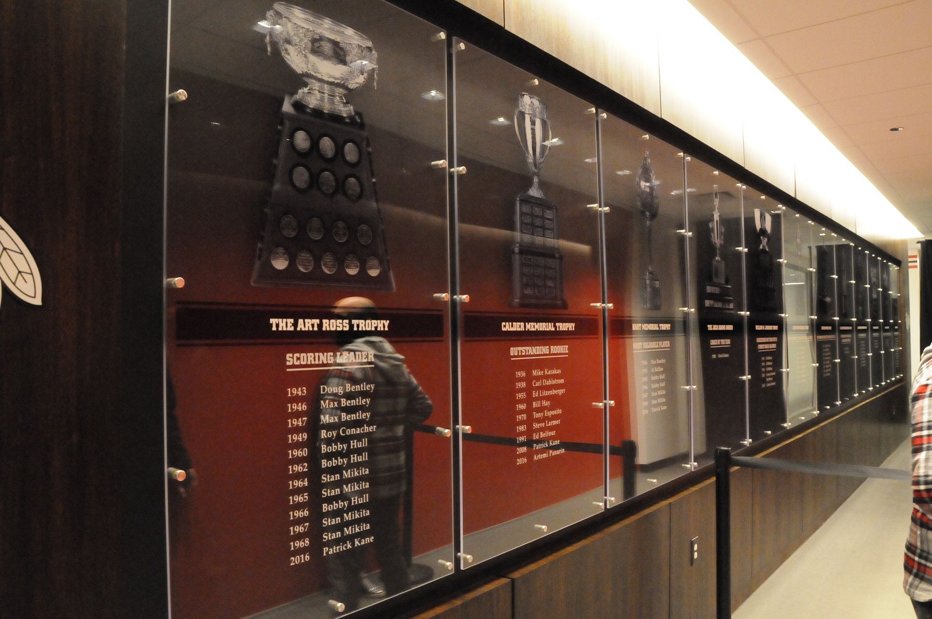 A long hallway with trophies displayed on the wall