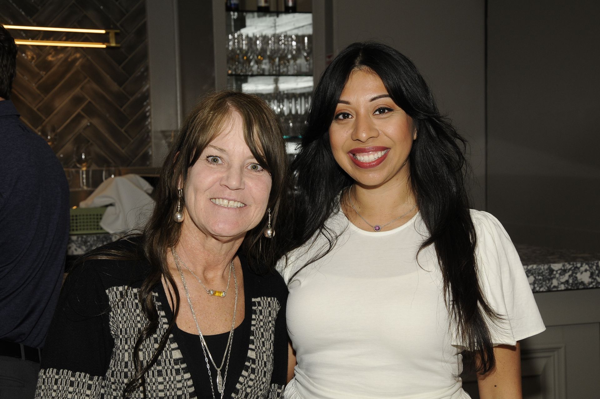 Two women are posing for a picture and smiling for the camera