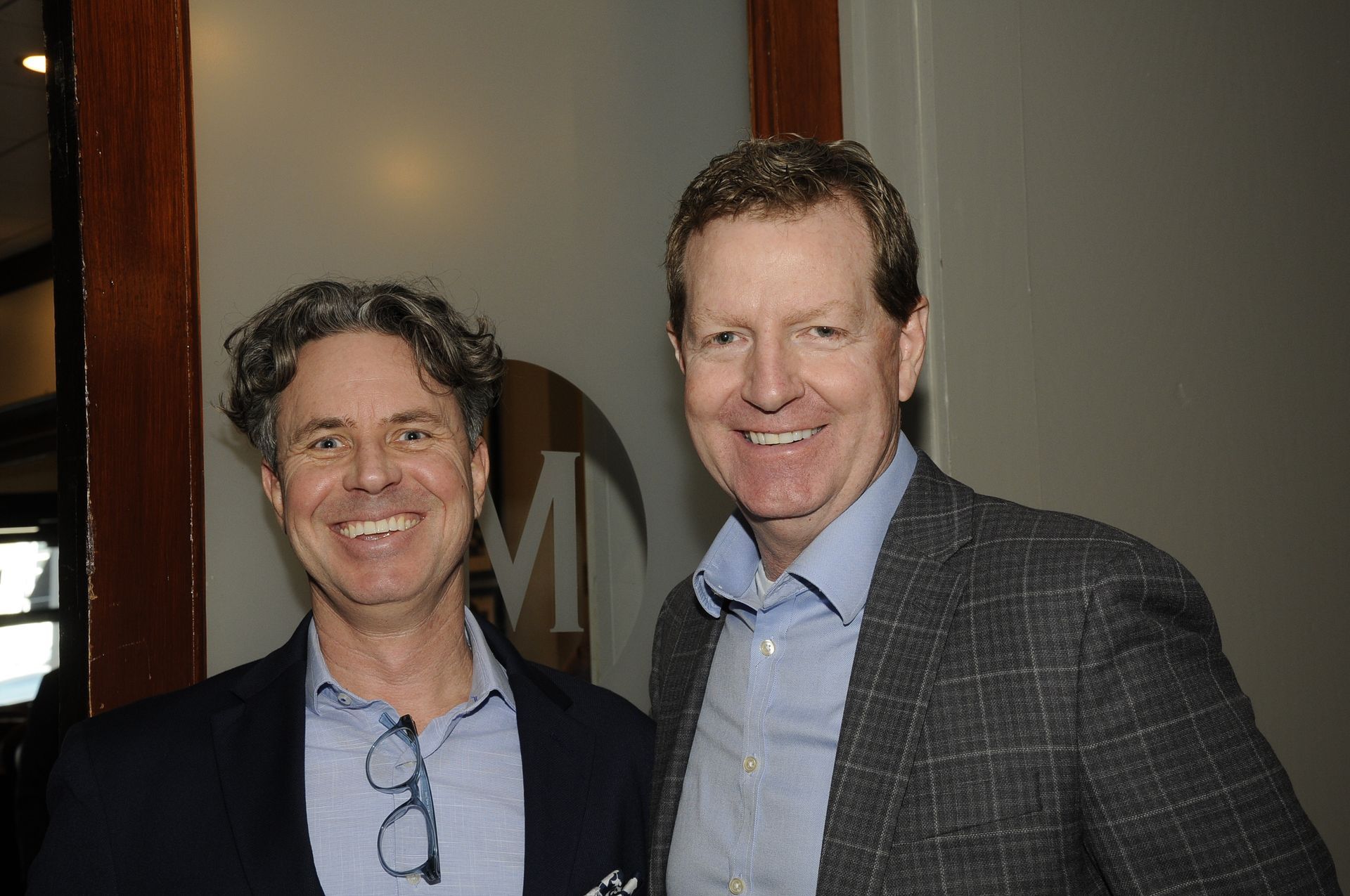 Two men are standing next to each other and smiling for the camera.