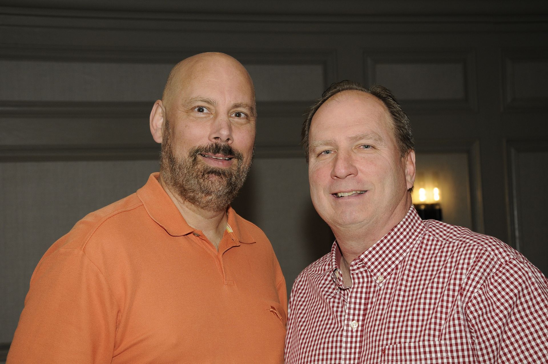 Two men are standing next to each other and smiling for the camera.