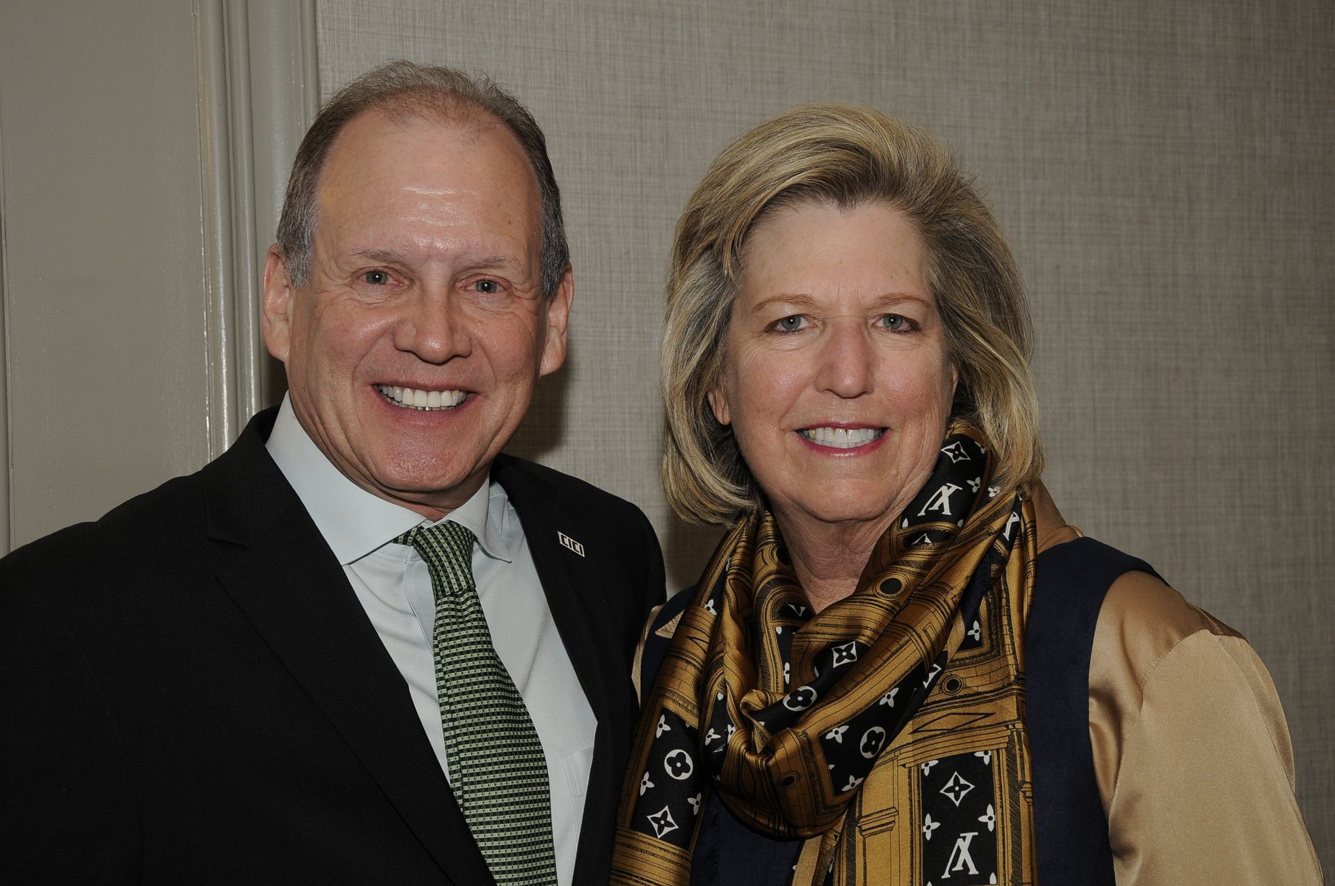A man and a woman are posing for a picture and smiling