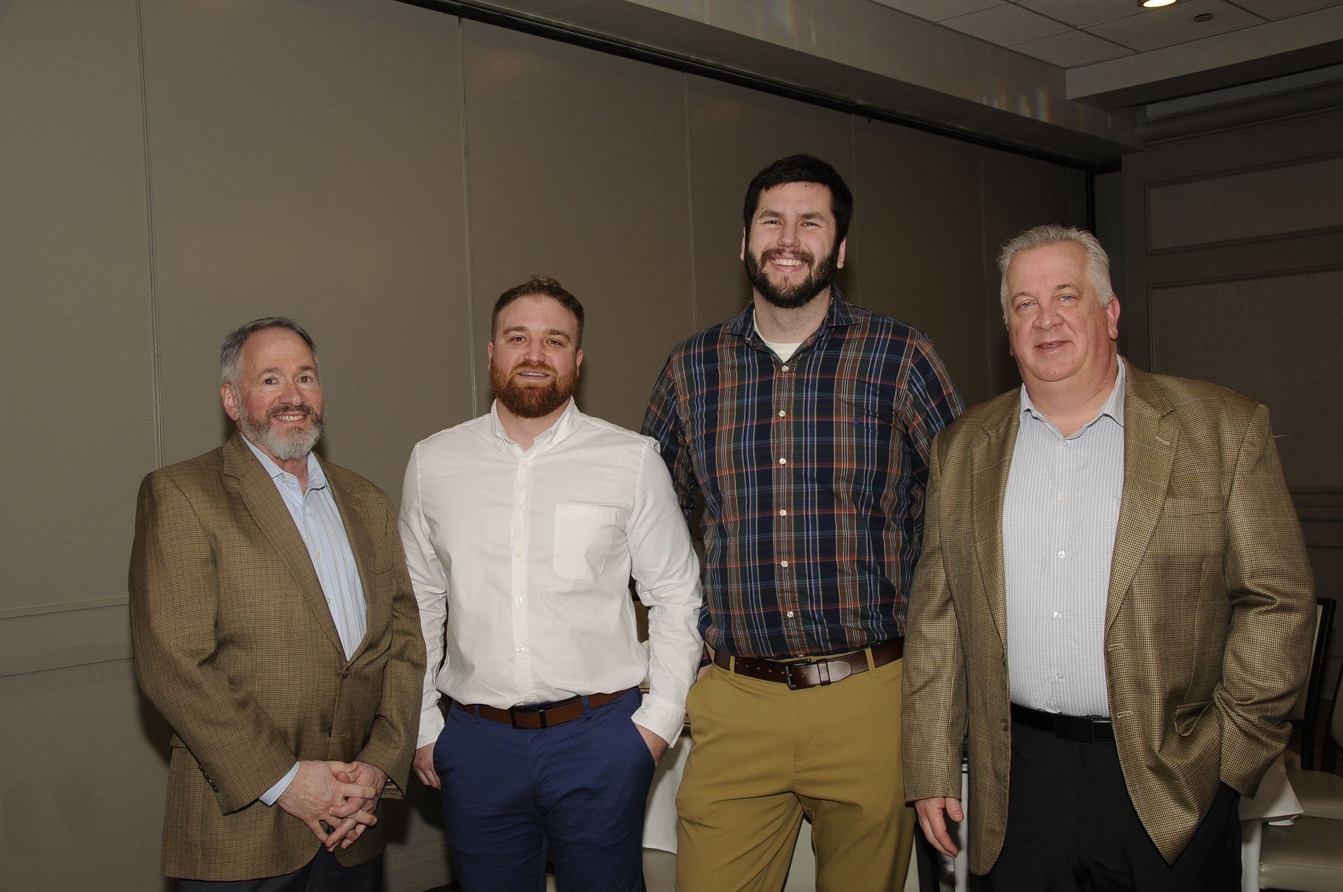A group of men are standing next to each other in a room.
