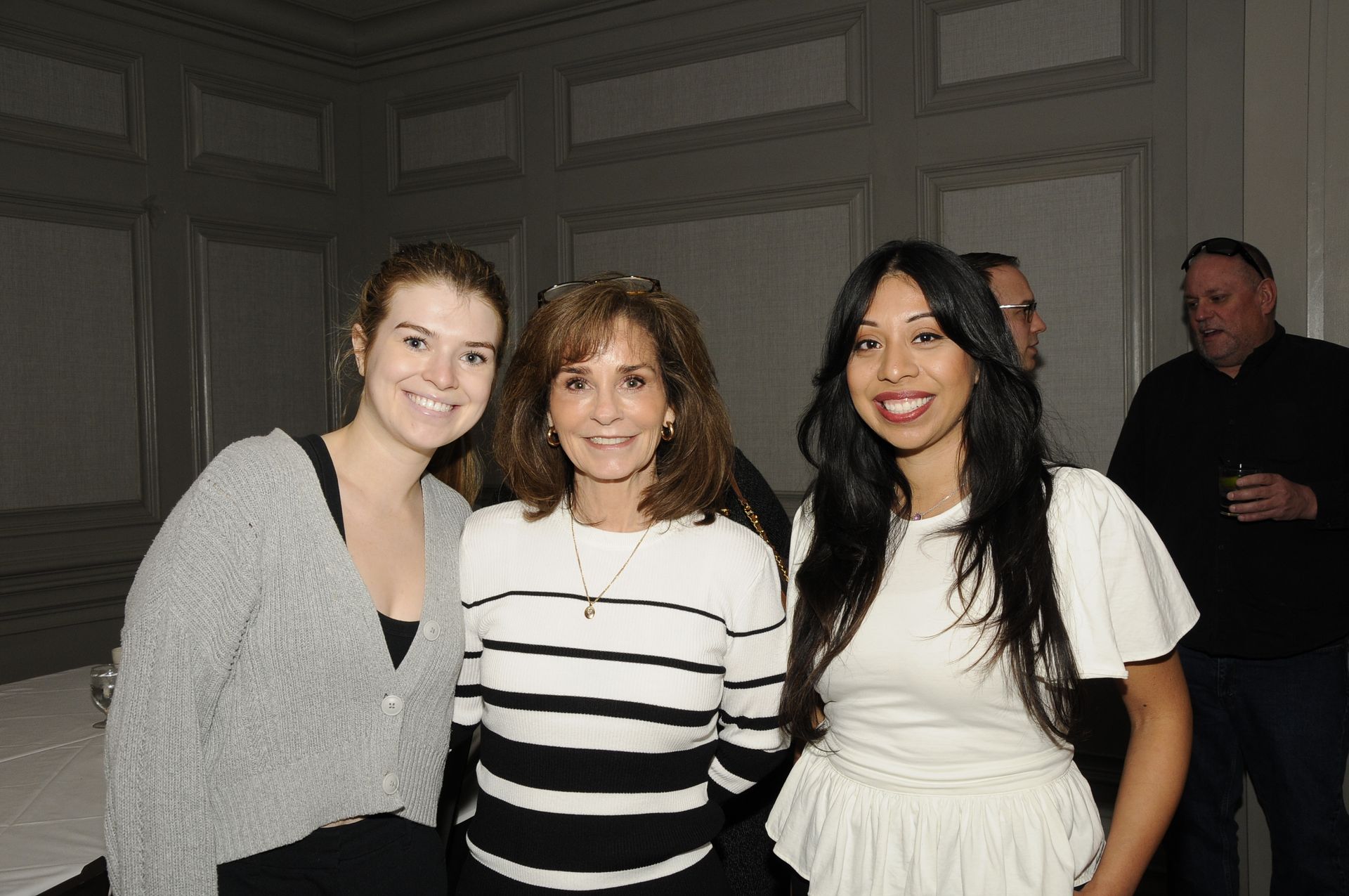 Three women are posing for a picture together in a room.