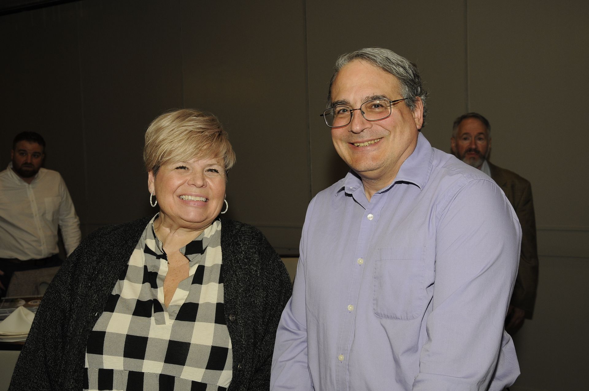 A man and a woman are standing next to each other and smiling.