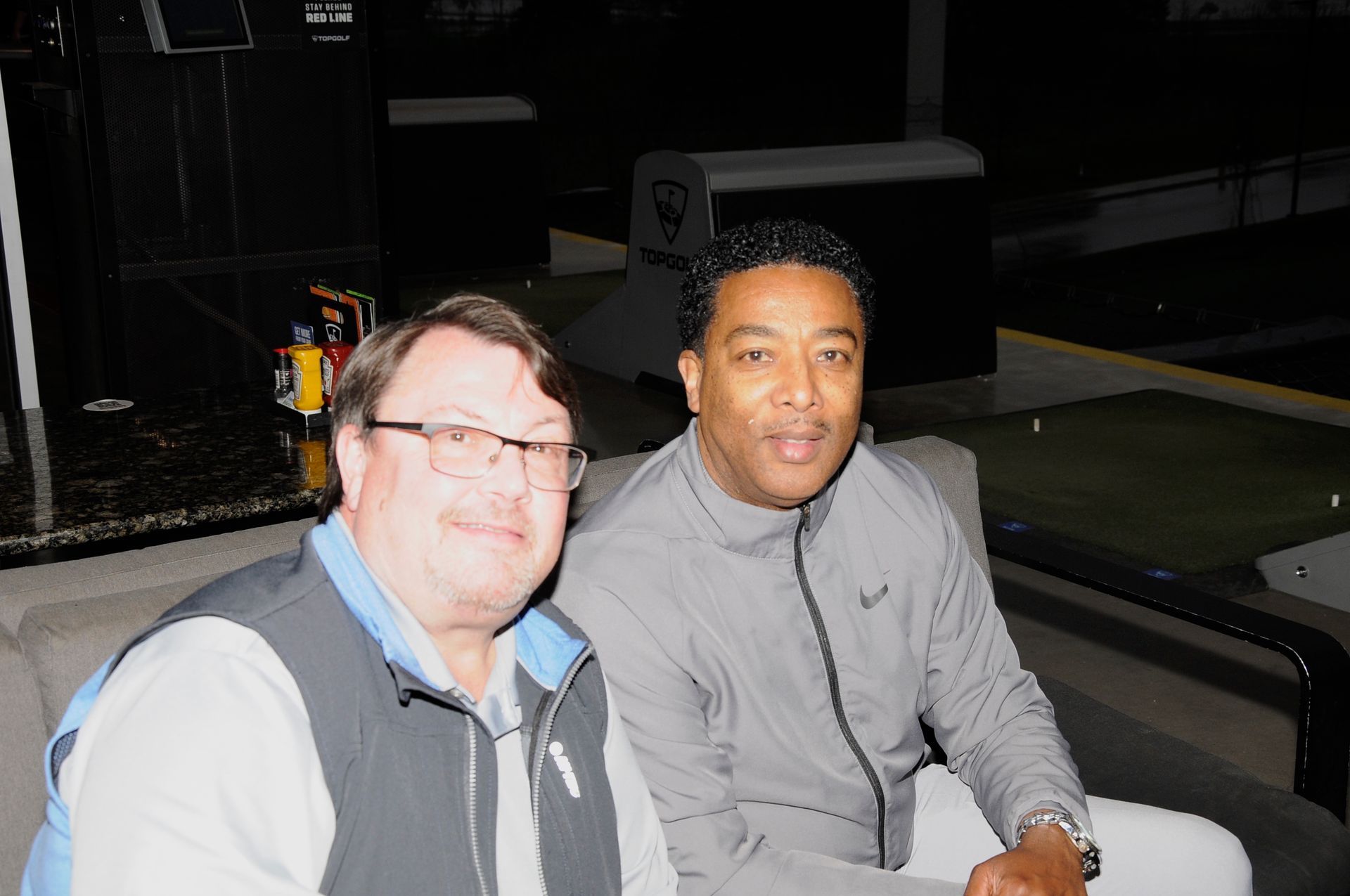 Two men are sitting next to each other on a couch.