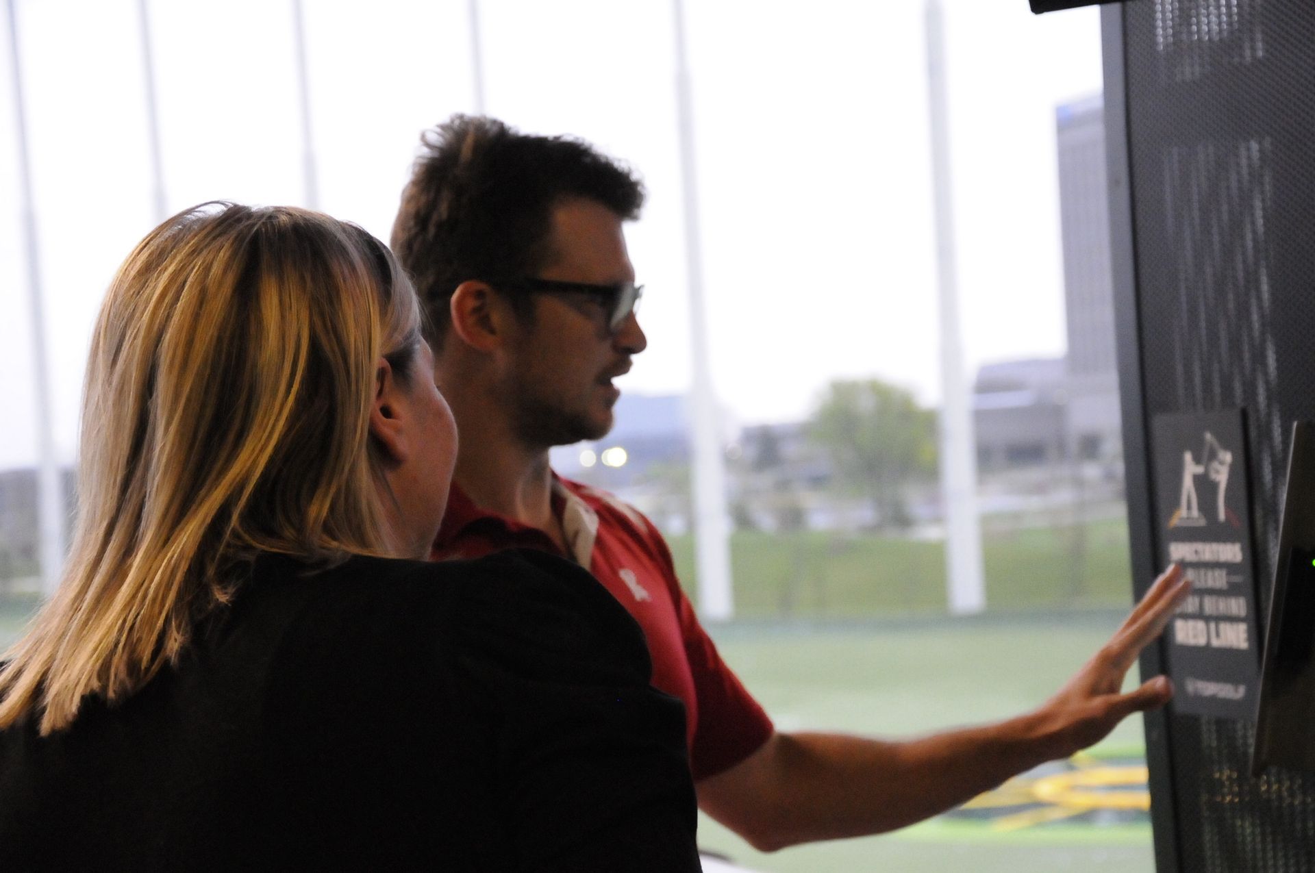 A man and a woman are looking at a chalkboard