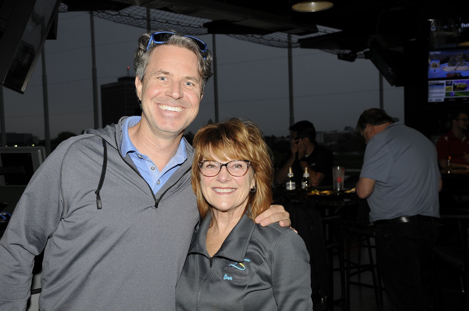 A man and a woman are posing for a picture in a bar.