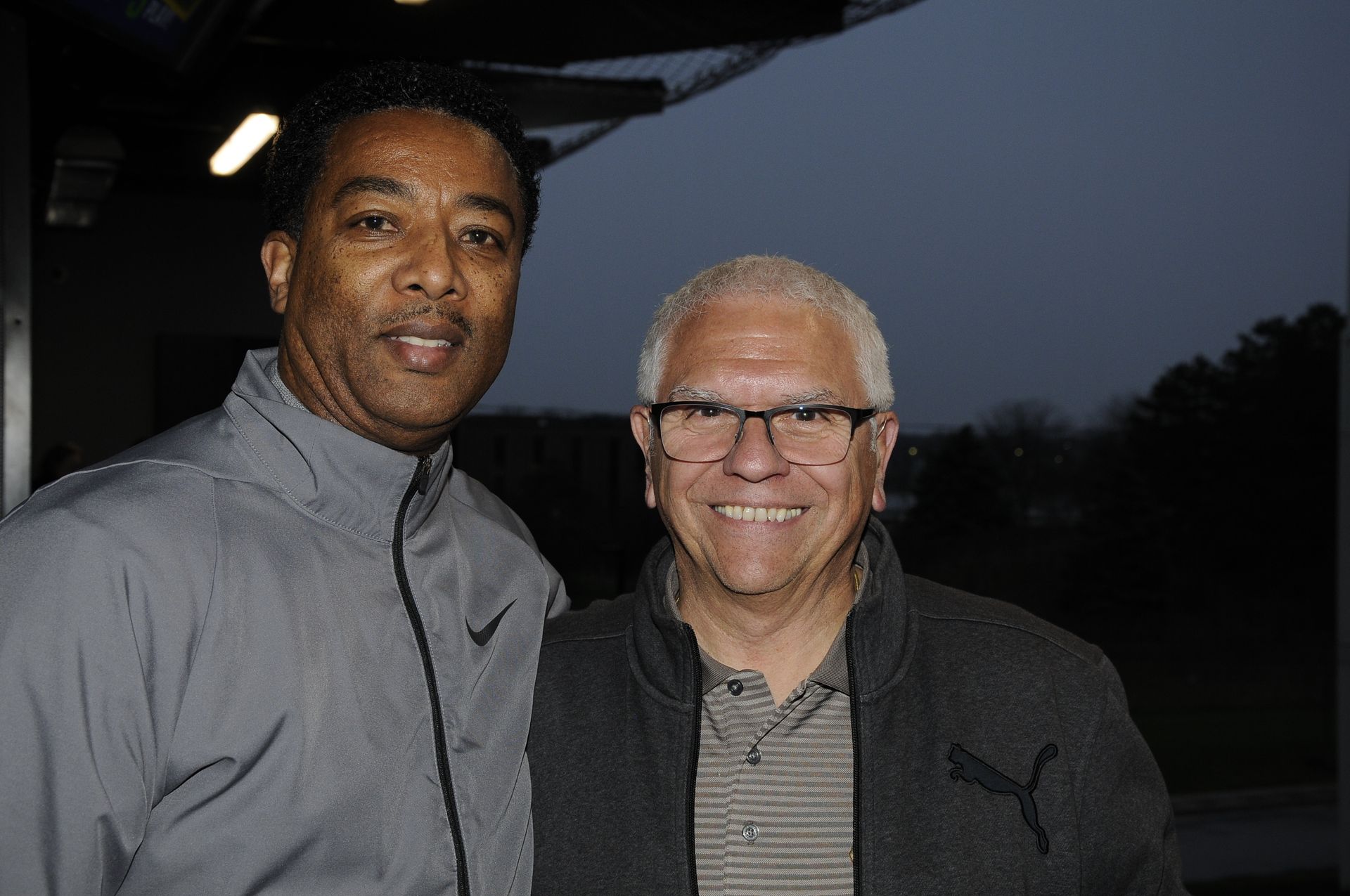 Two men are posing for a picture together and smiling for the camera.