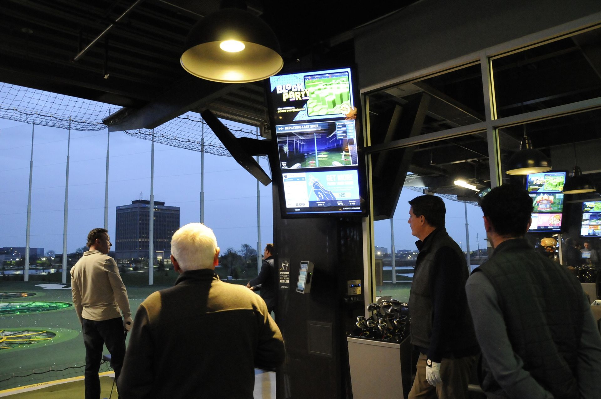 A group of people are standing in front of a large screen