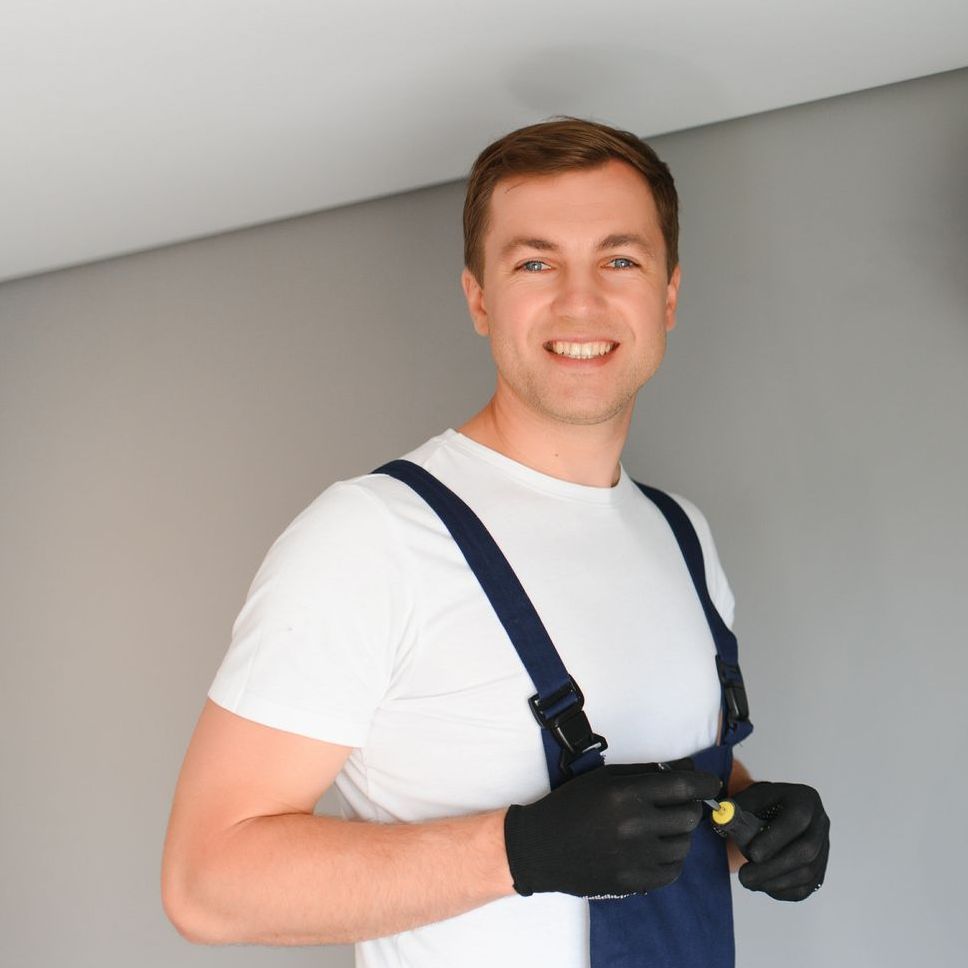 a man wearing overalls and a white shirt is smiling for the camera