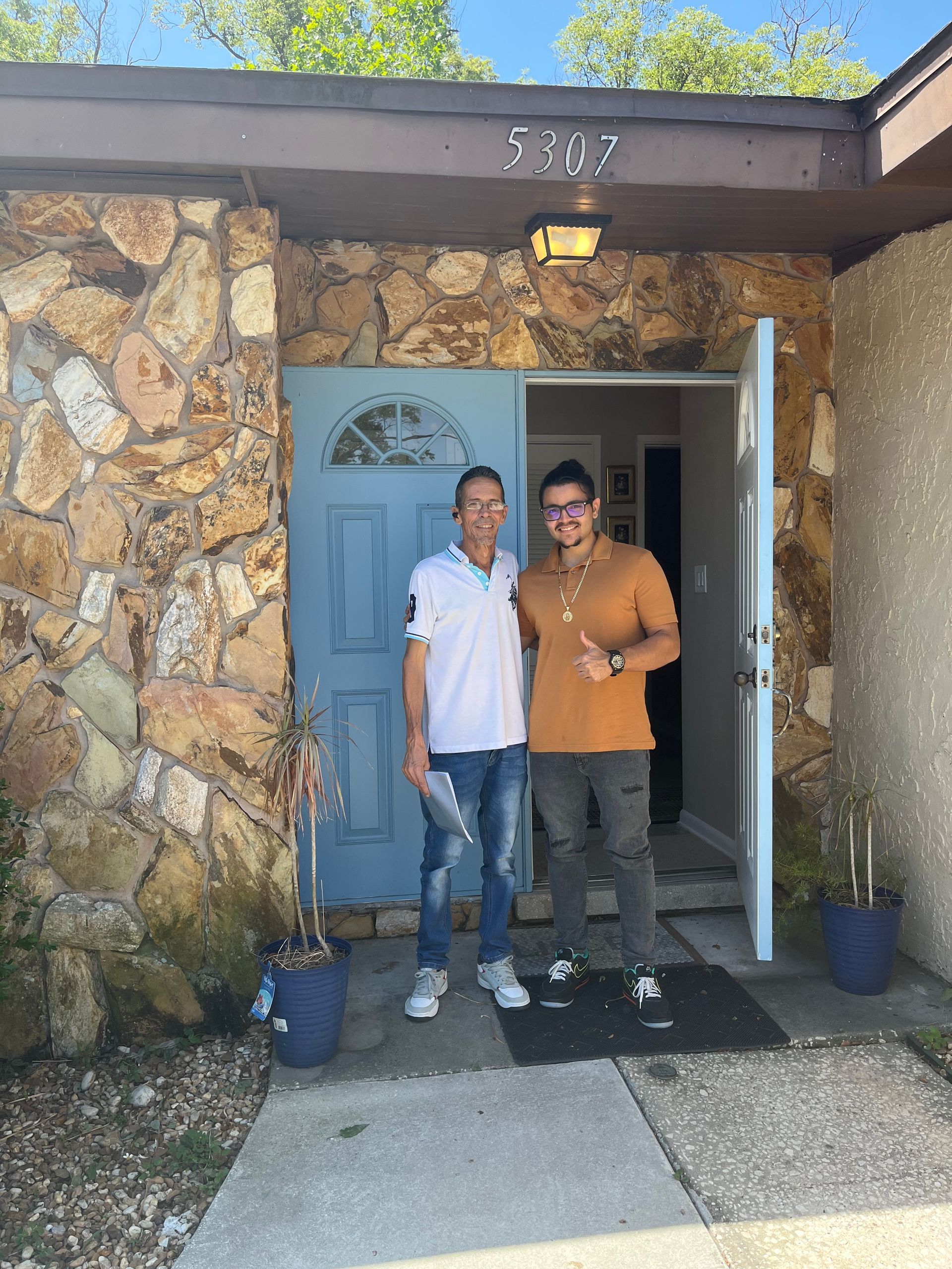 A living room with a couch , chairs , ottoman and a mirror