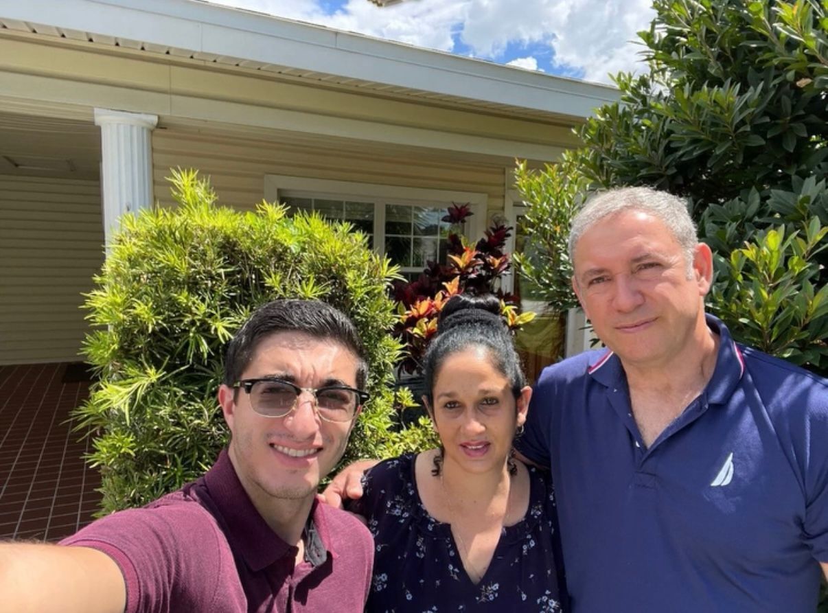 A patio with a lot of furniture and lights at night.