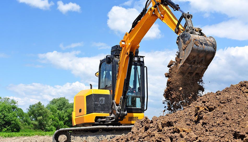 Yellow excavator digging dirt under a blue sky.