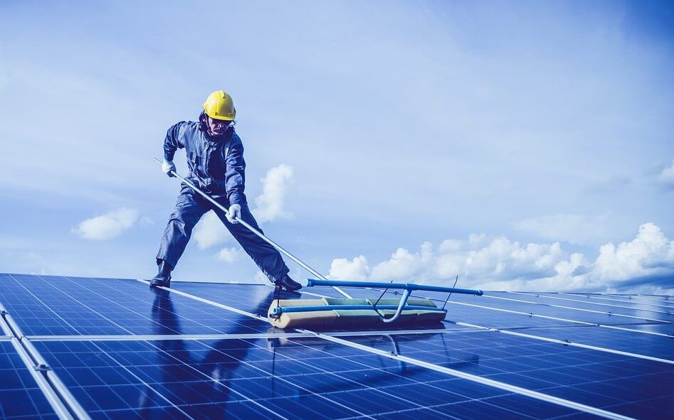 man cleaning solar panels
