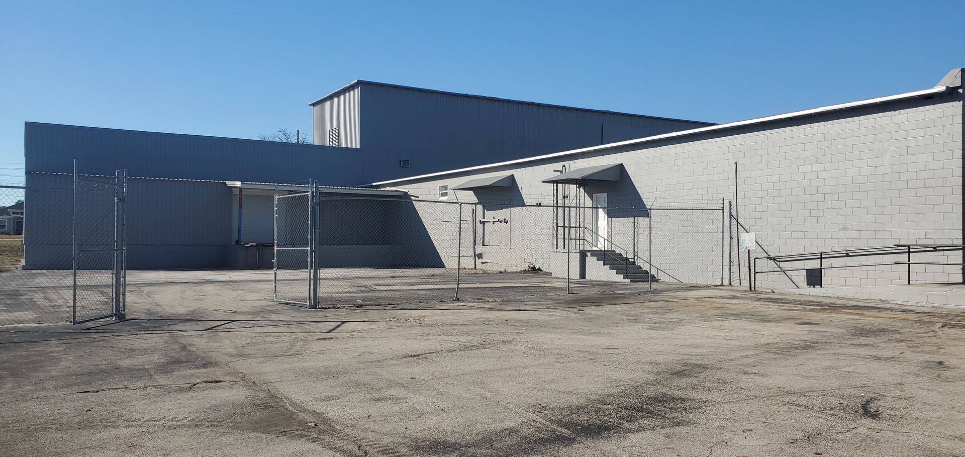 A fenced in area with a brick building in the background