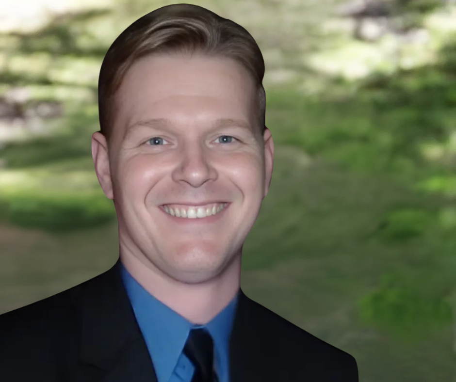 A man in a suit and tie smiles for the camera
