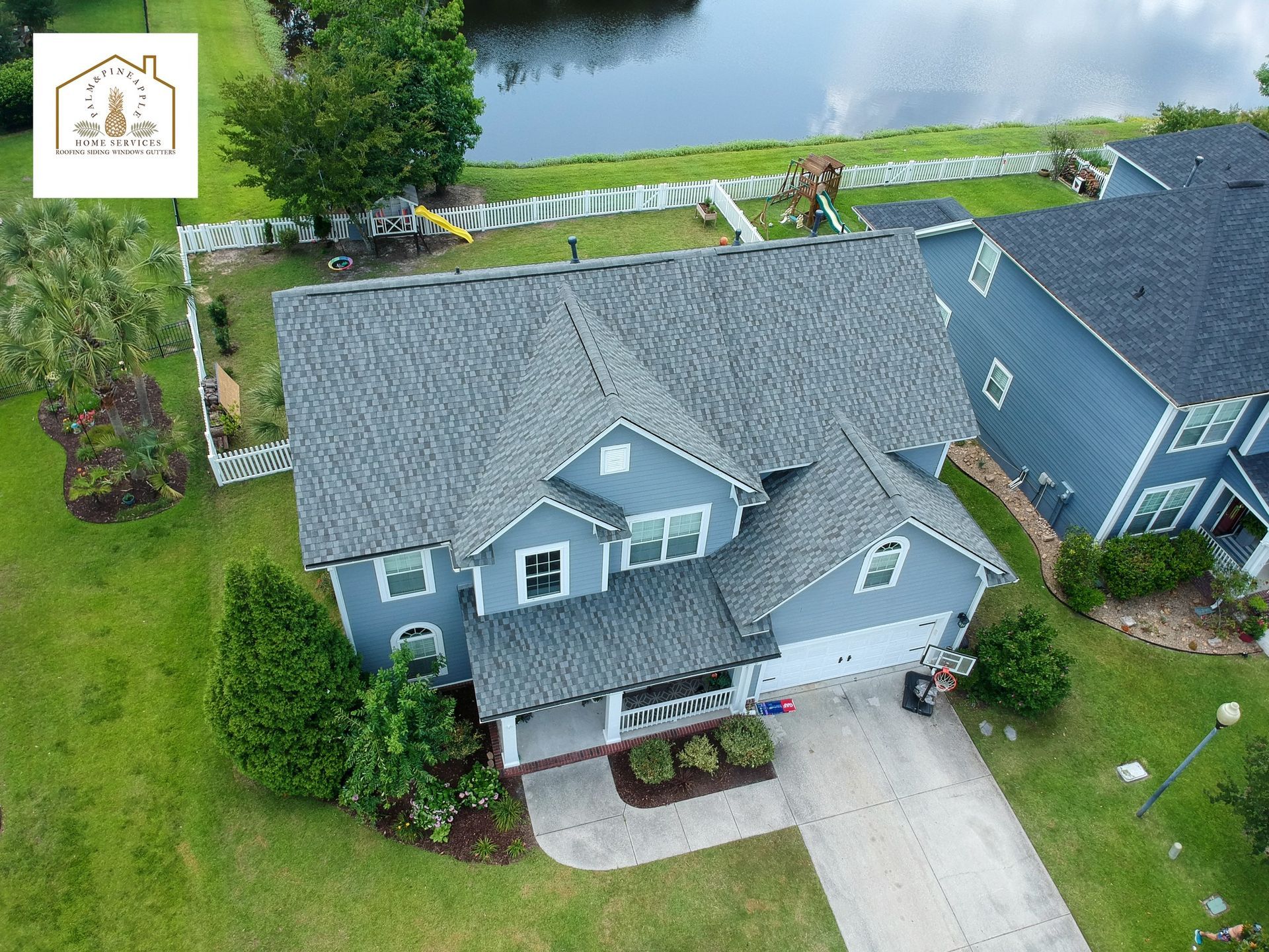 An aerial view of a house with a lake in the background